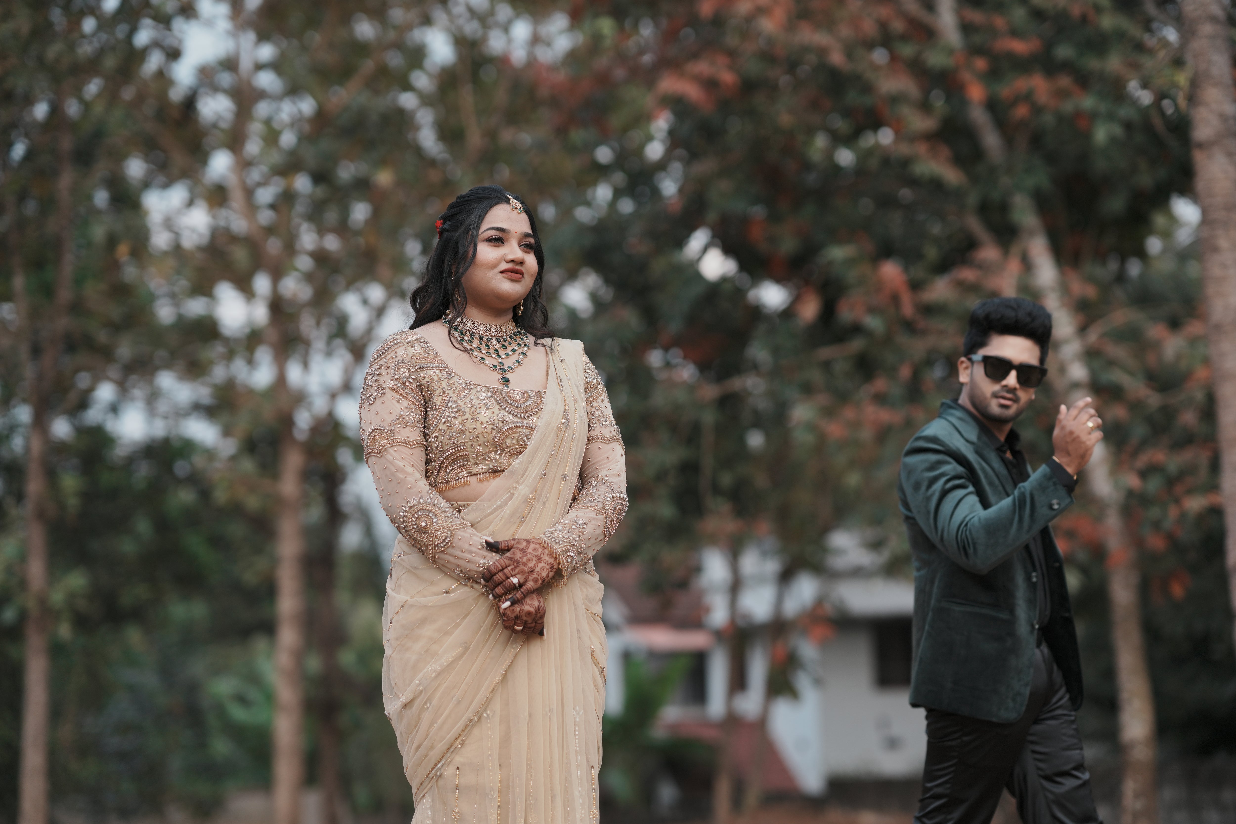 Bride Chithira from Australia, posing with groom in a golden tulle saree by team Archana Karthick.