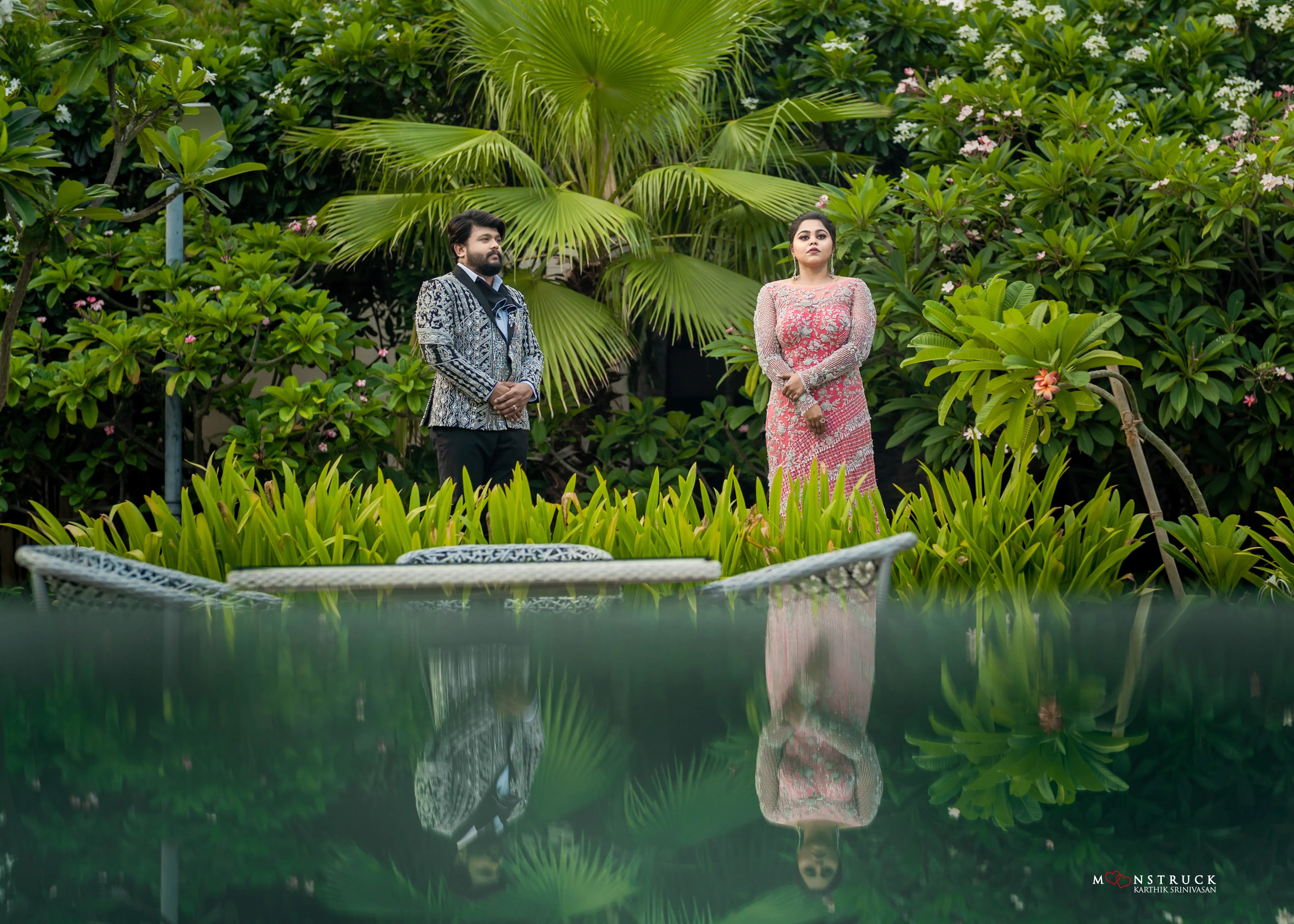 Bride (Coimbatore) in handcrafted pink tulle gown and and Groom (Chennai) in embeliished jacket for their reception posing near swiming pool.