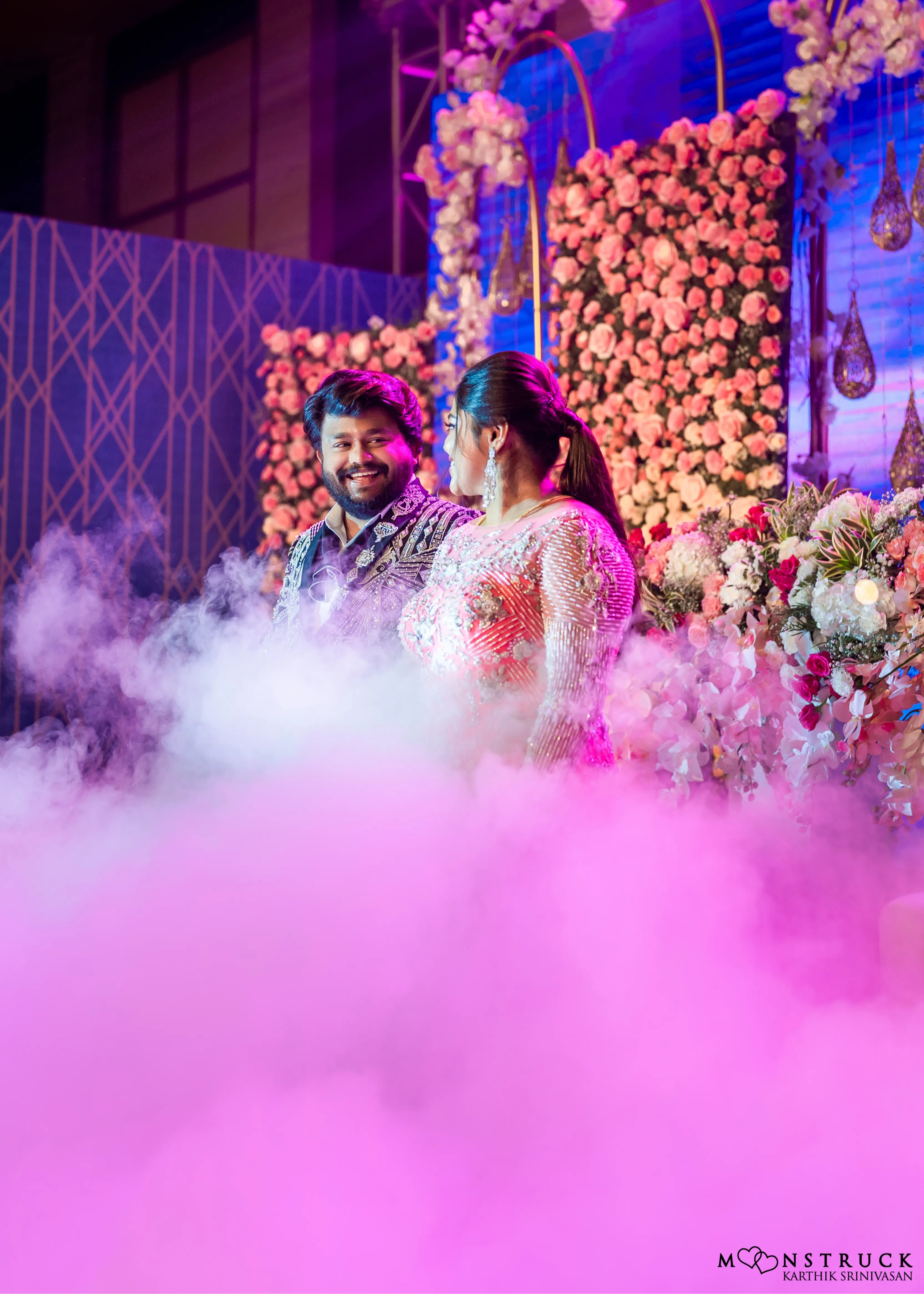 Bride (Coimbatore) in handcrafted pink tulle gown and and Groom (Chennai) in embeliished jacket for their reception smiling.