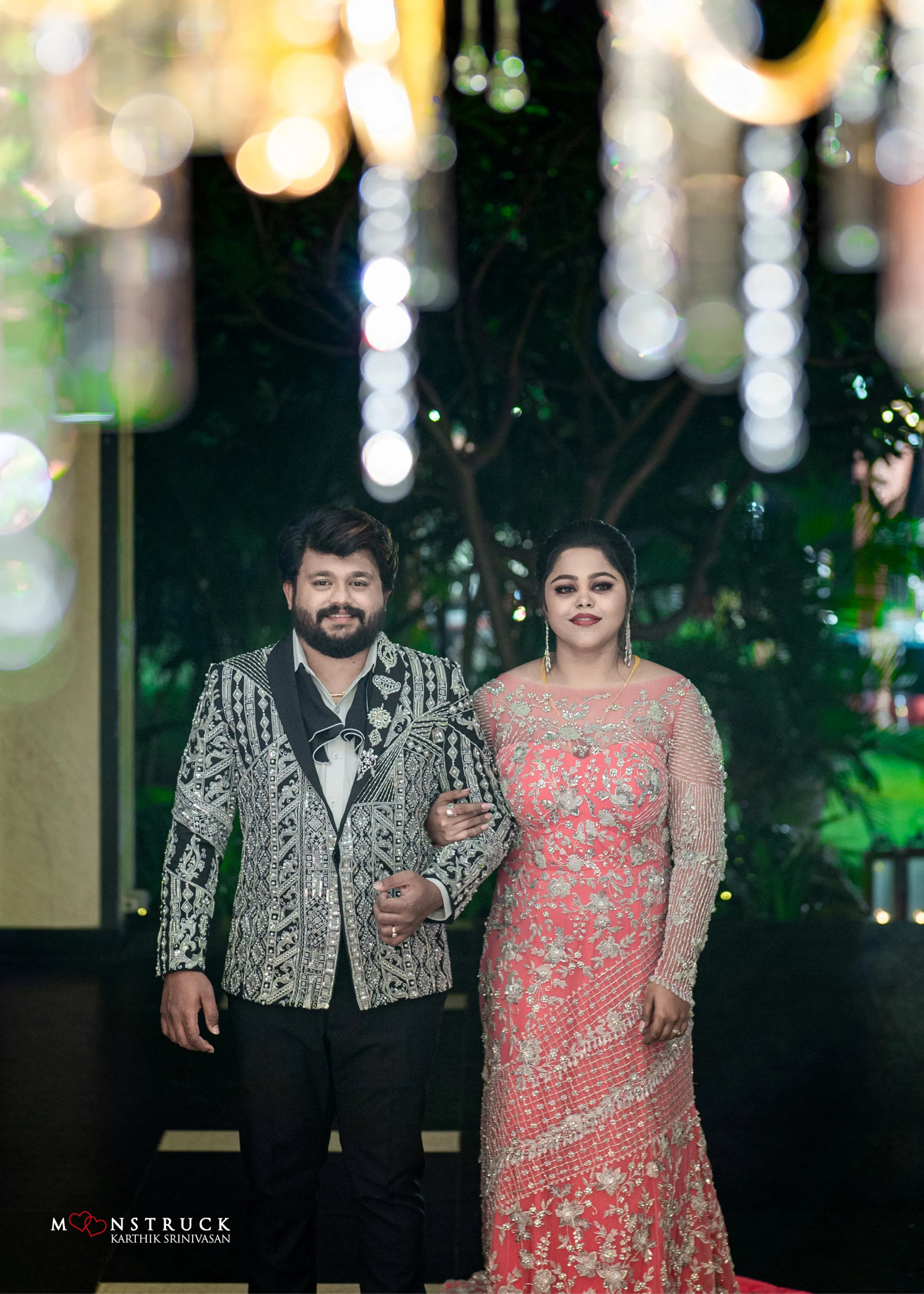 Bride (Coimbatore) in handcrafted pink tulle gown and and Groom (Chennai) in embeliished jacket for their reception walking together.