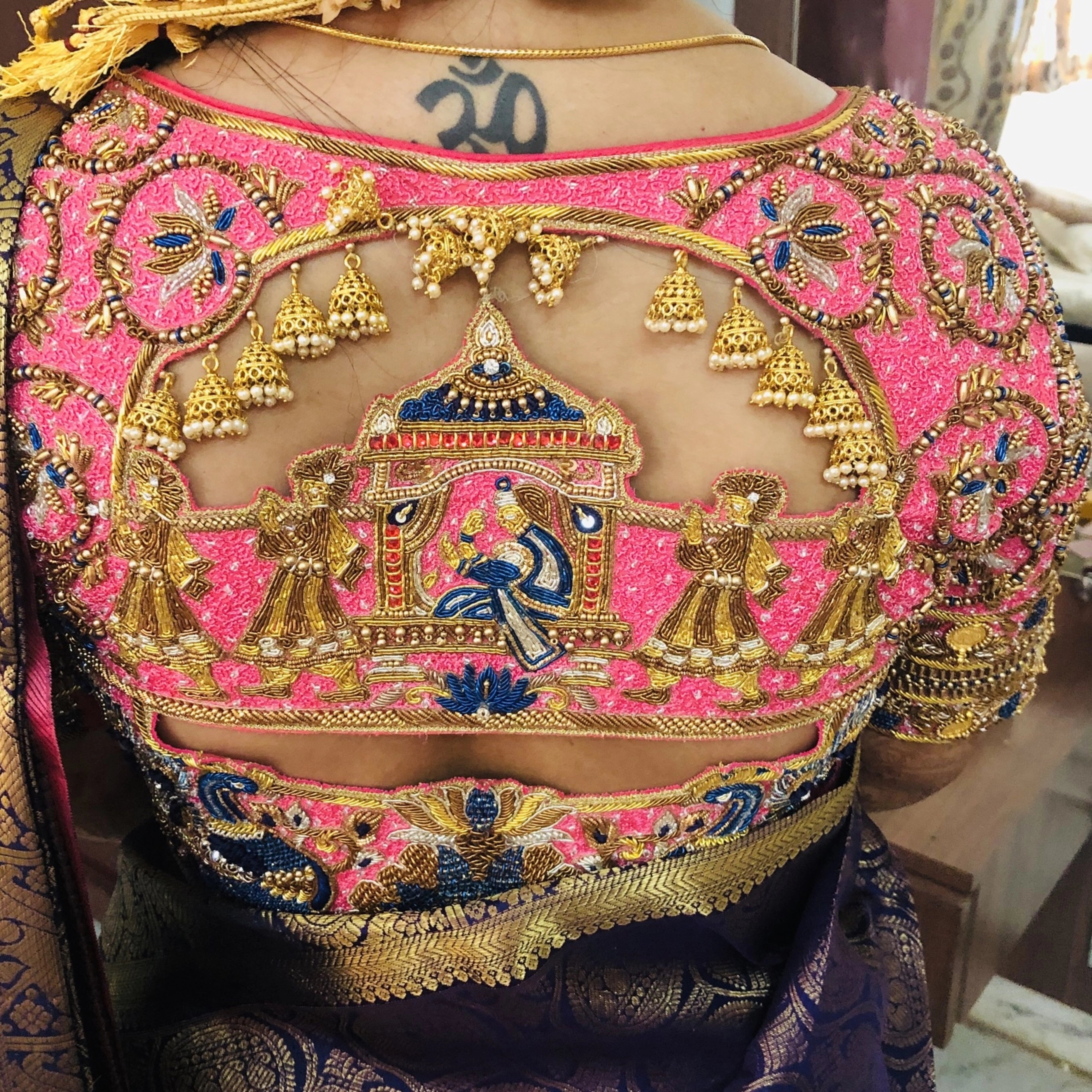 Bride Deepa posing in a pink raw silk palanquin concept blouse, handcrafted with stones, resham, zardozi, sequins, beads, cutdana and jhumkas by team Archana Karthick.