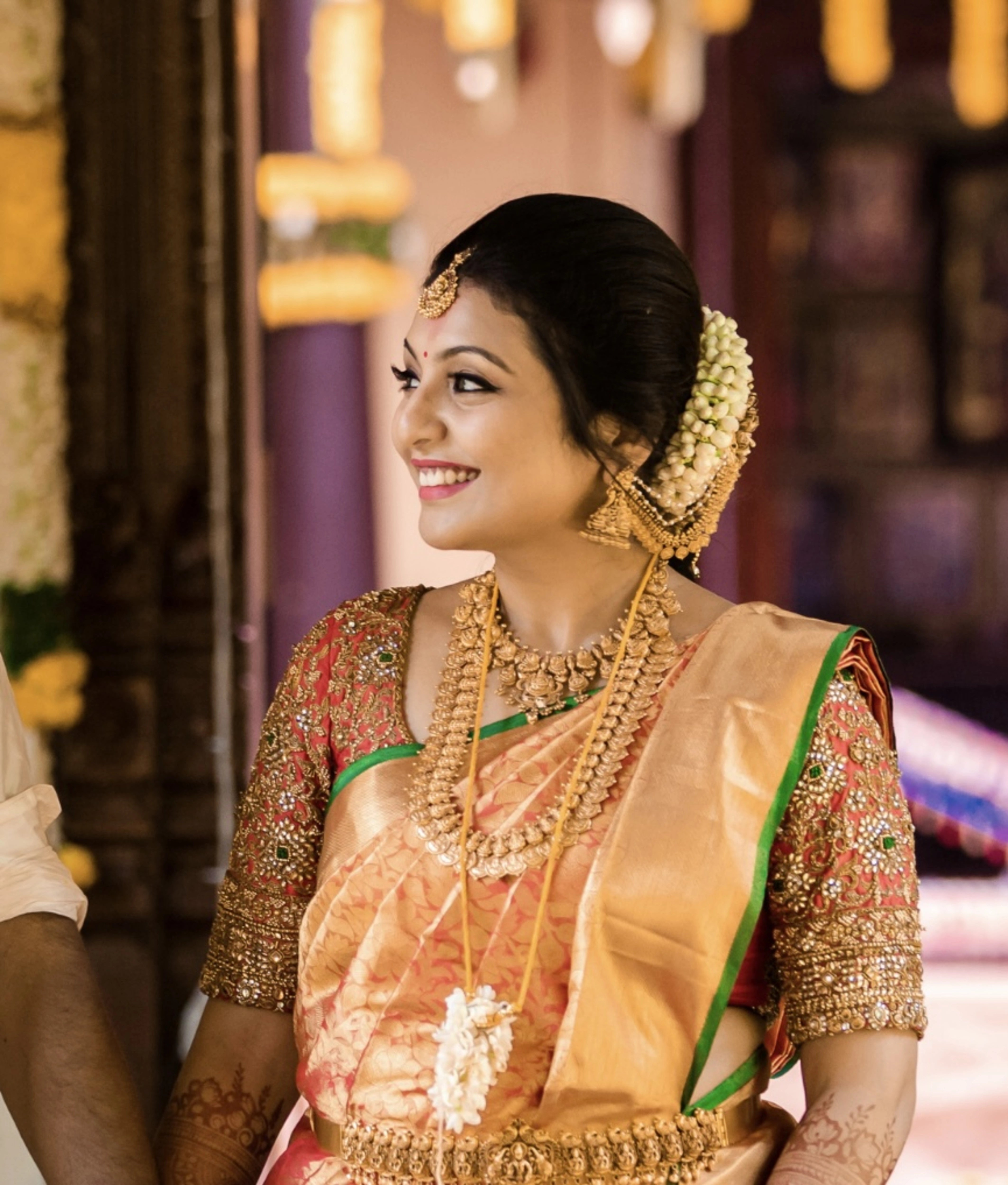 Bride Deepachitra in a vermilion silk blouse with the palanquin concept. Intricately handcrafted with stones, resham, zardozi, beads and cutdana by team Archana Karthick.