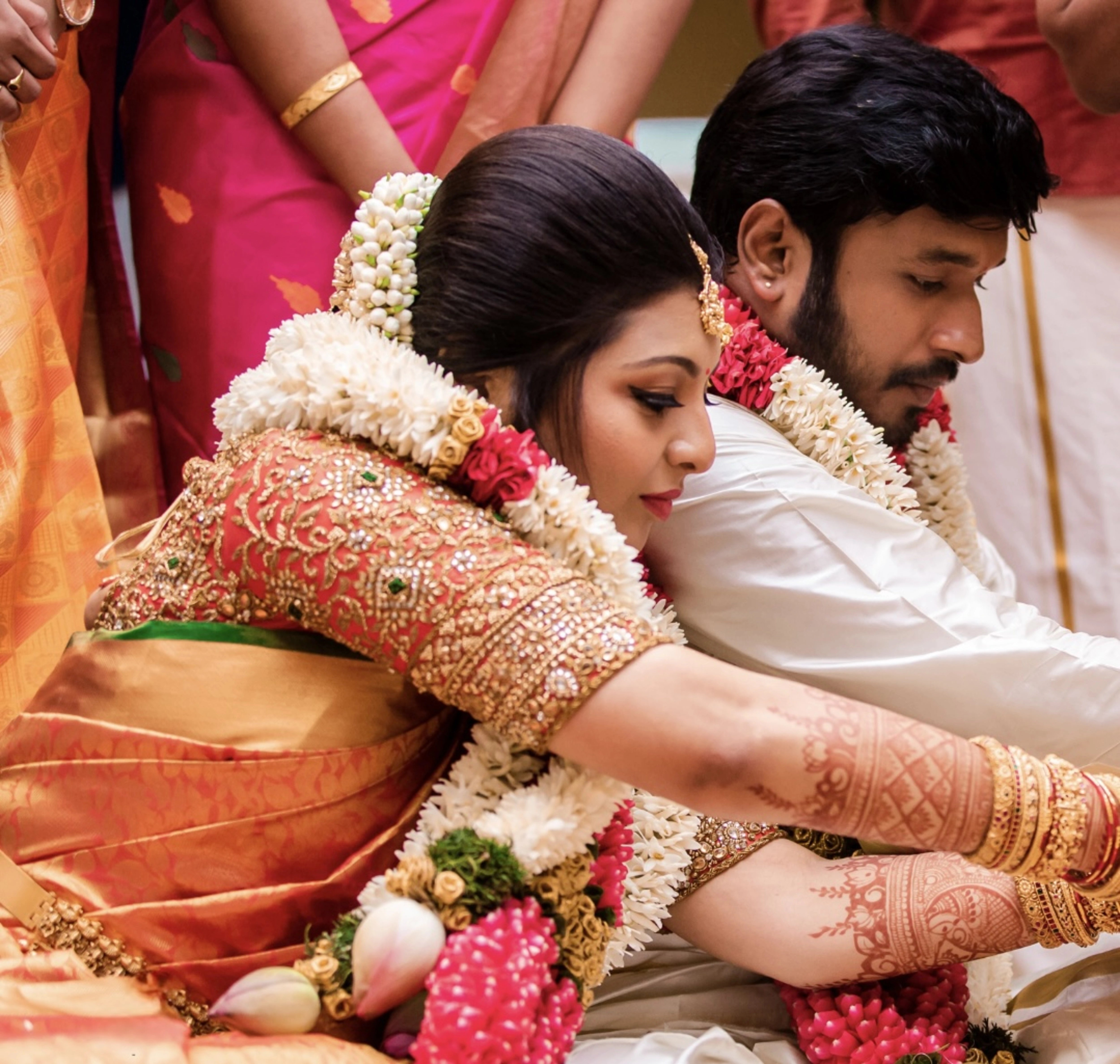 Bride Deepachitra with groom in a vermilion silk blouse with the palanquin concept. Intricately handcrafted with stones, resham, zardozi, beads and cutdana by team Archana Karthick.