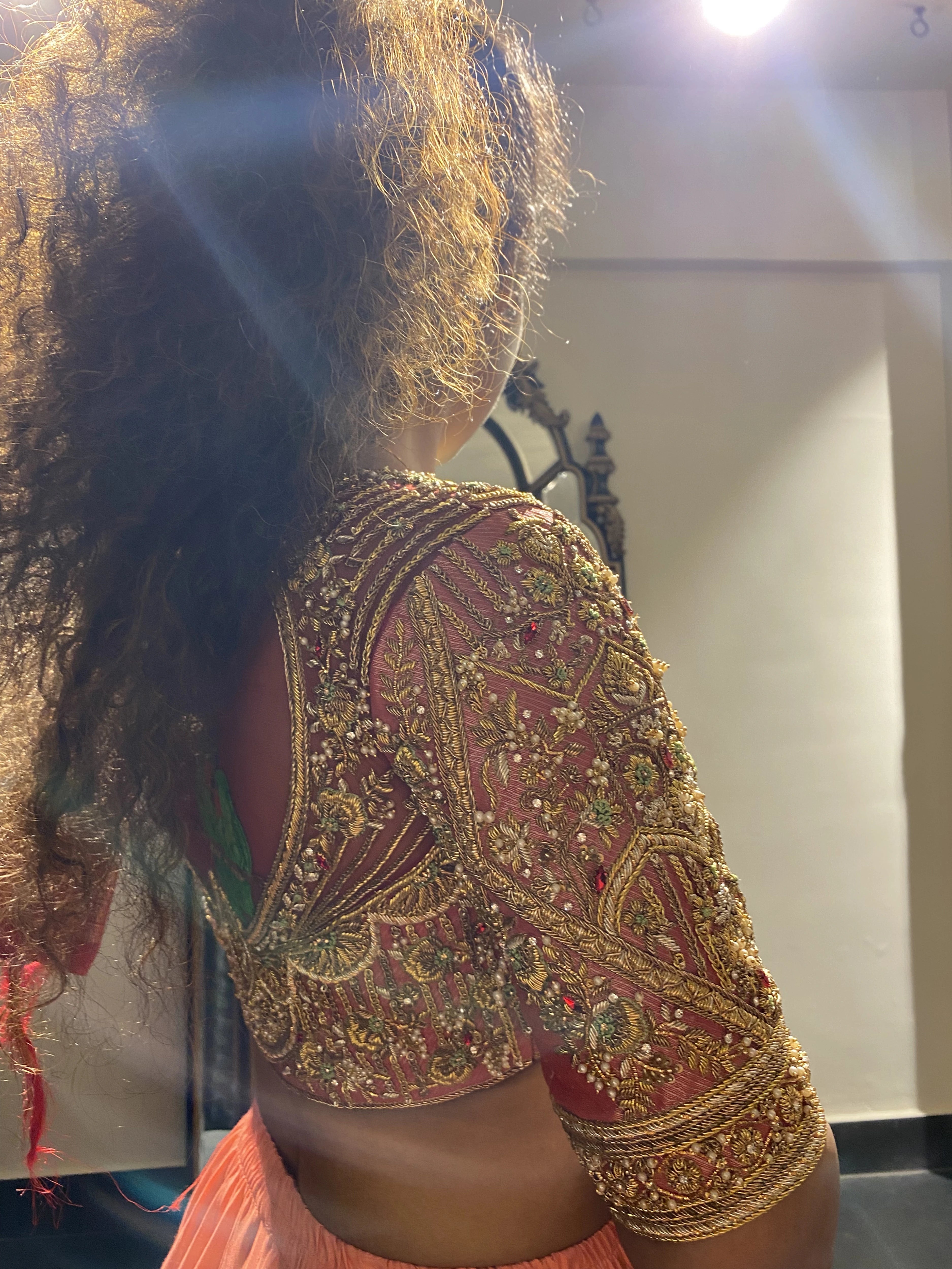 Bride Divya in a red silk blouse handcrafted by team Archana Karthick.