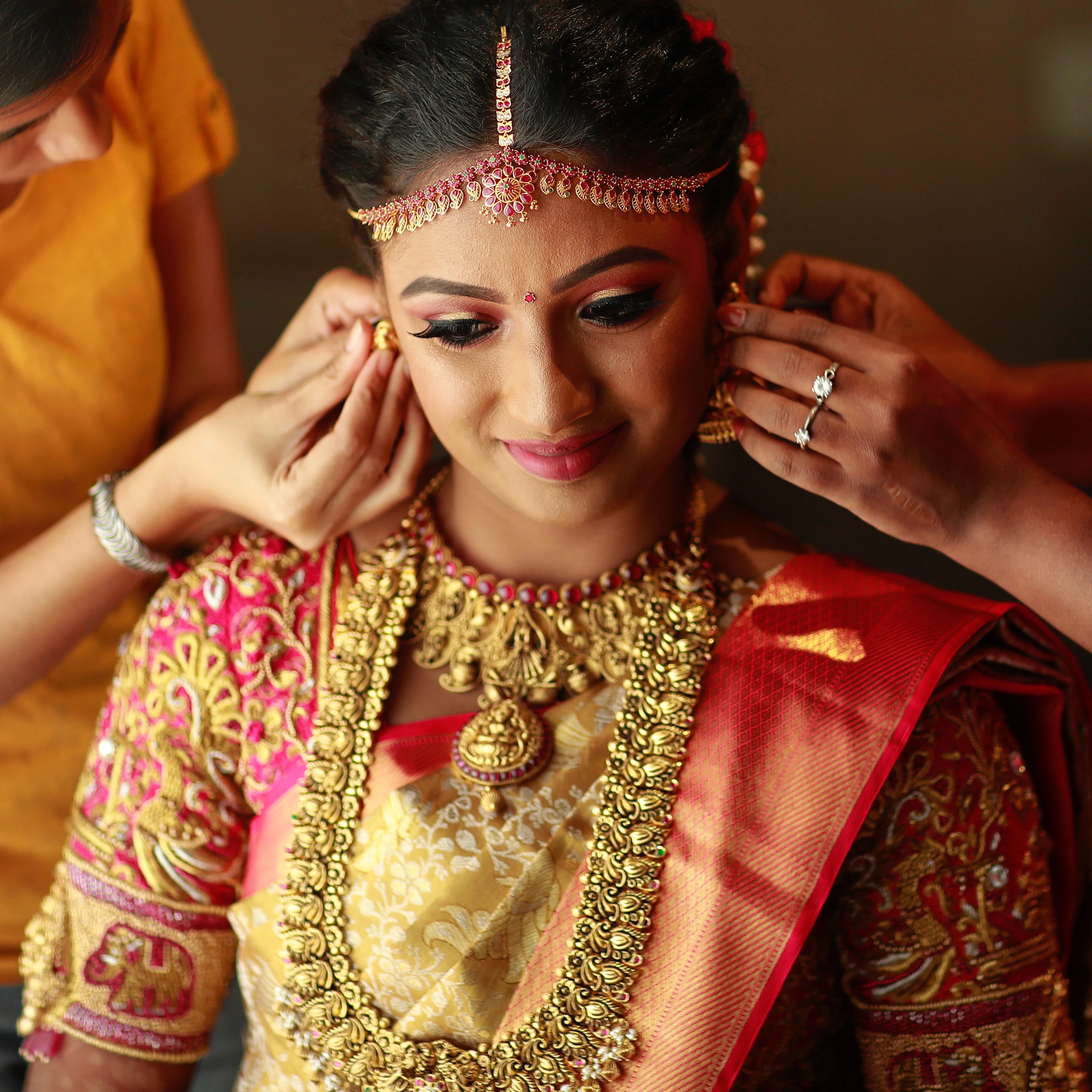 Bride Divyaa during makeup in a pink raw silk palanquin concept blouse handcrafted intricately with zardozi, resham, crystals and beads designed by Archana Karthick.