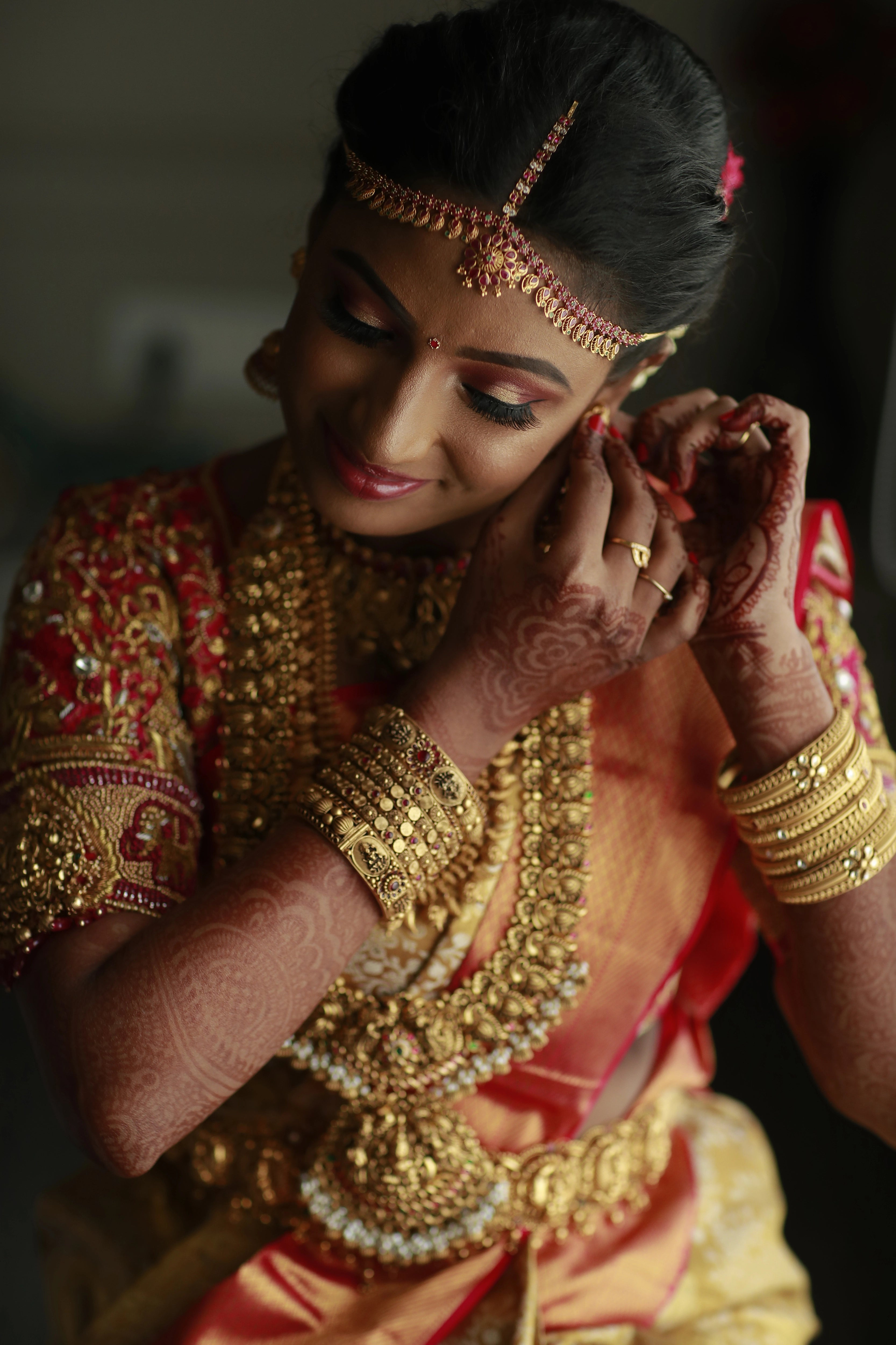 Bride Divyaa posing in a pink raw silk palanquin concept blouse handcrafted intricately with zardozi, resham, crystals and beads designed by Archana Karthick.