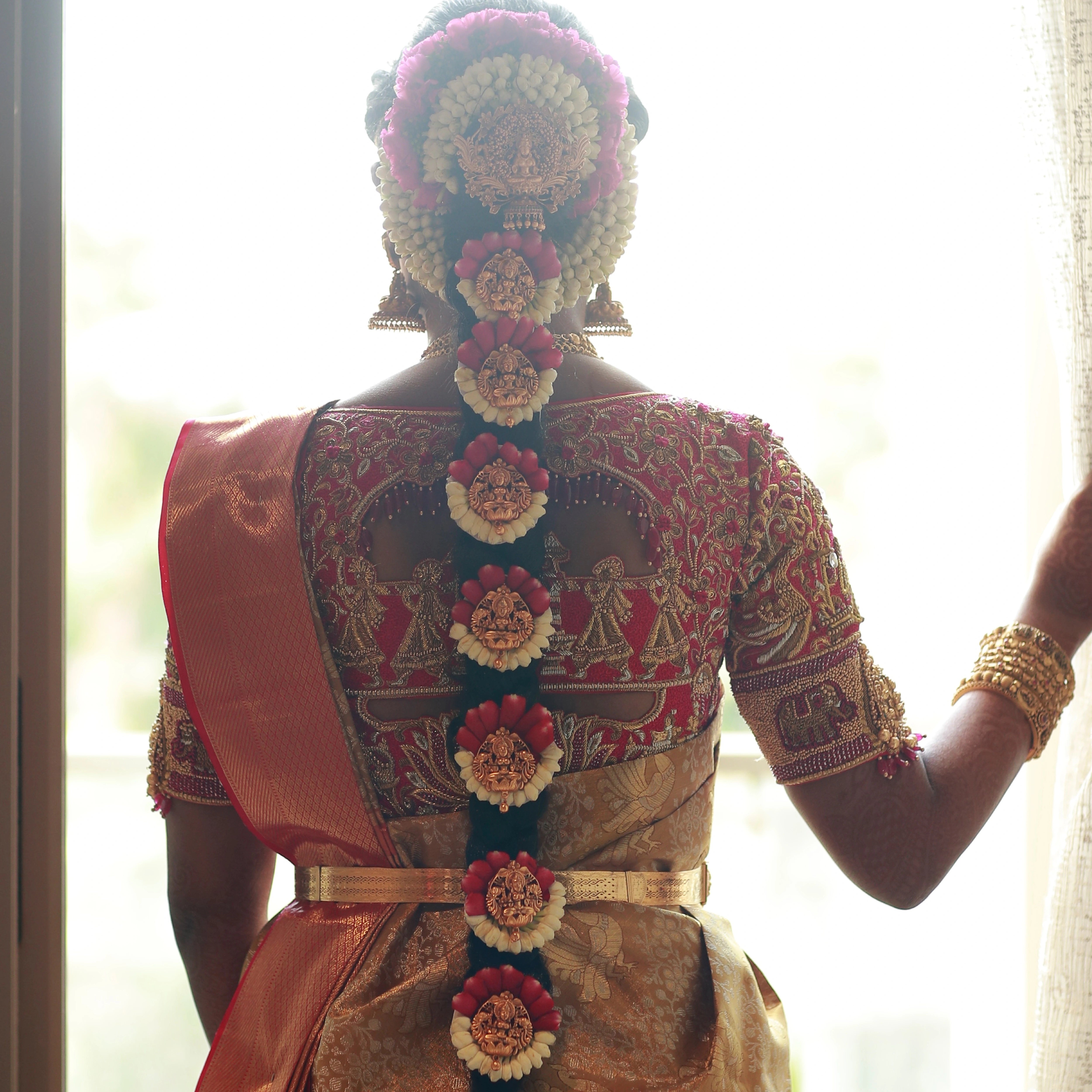 Bride Divyaa showcasing back blouse design in a pink raw silk palanquin concept blouse handcrafted intricately with zardozi, resham, crystals and beads designed by Archana Karthick.