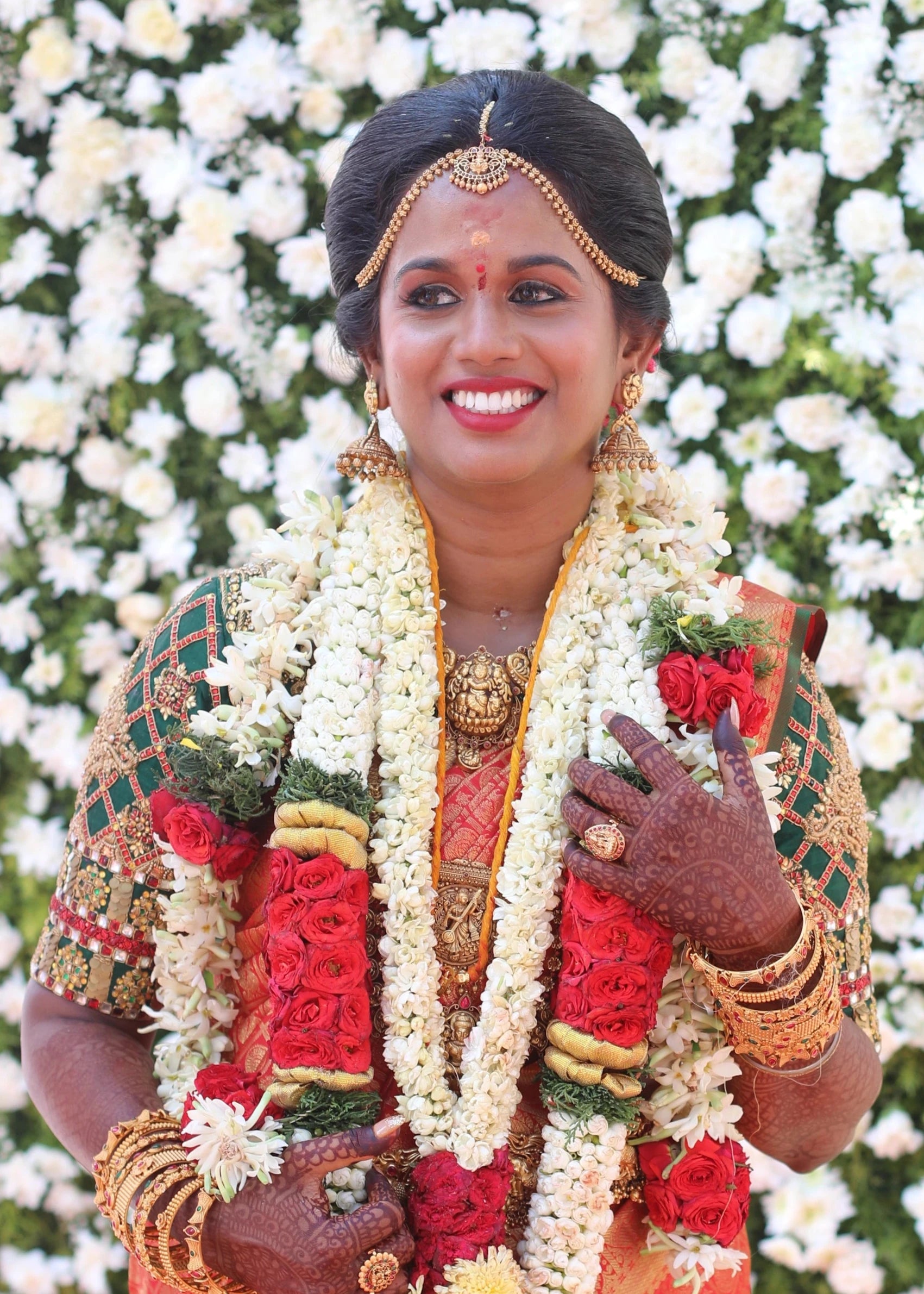 Bride Gayathri on stage in a palanquin concept bottle green silk blouse, handcrafted with kemp stones, zardozi, coins and crystals by team Archana Karthick.