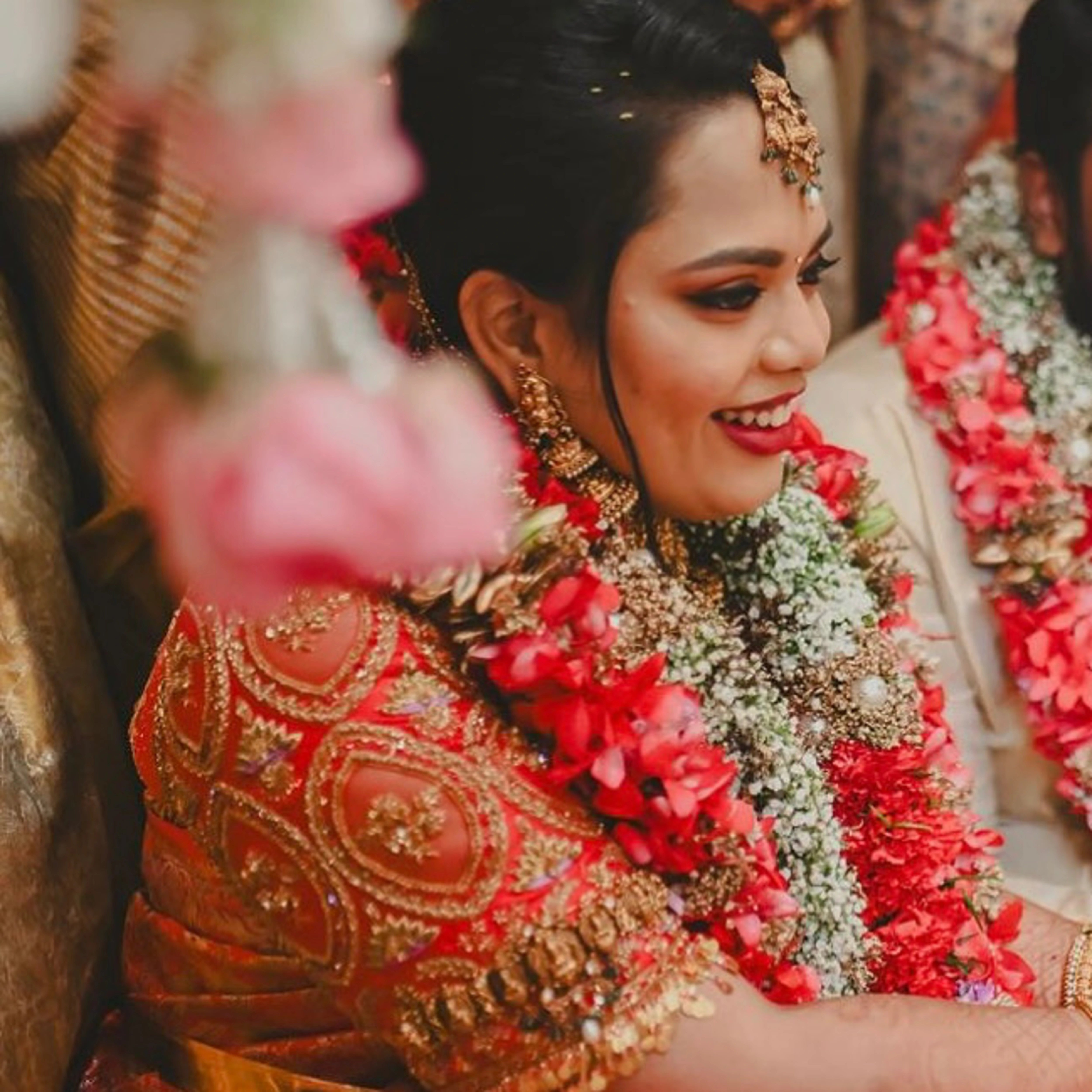 Bride Gayathri posing in a red silk blouse by team Archana Karthick.