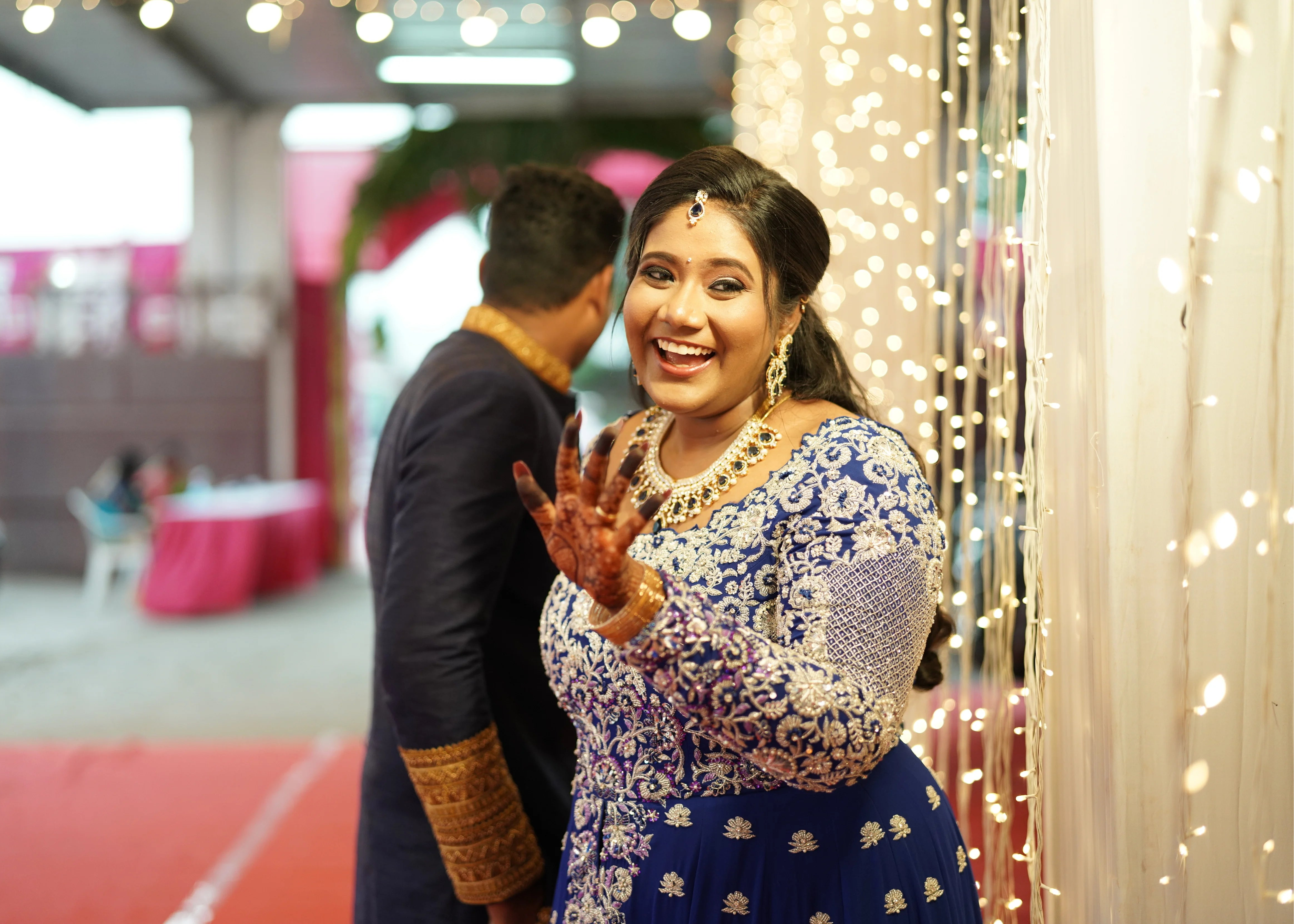 Bride & Groom from Dindigul, laughing in a midnight blue handcrafted masakali lehenga and navy blue raw silk sherwani with embellished collar, cuffs and borders. Designed by Archana Karthick