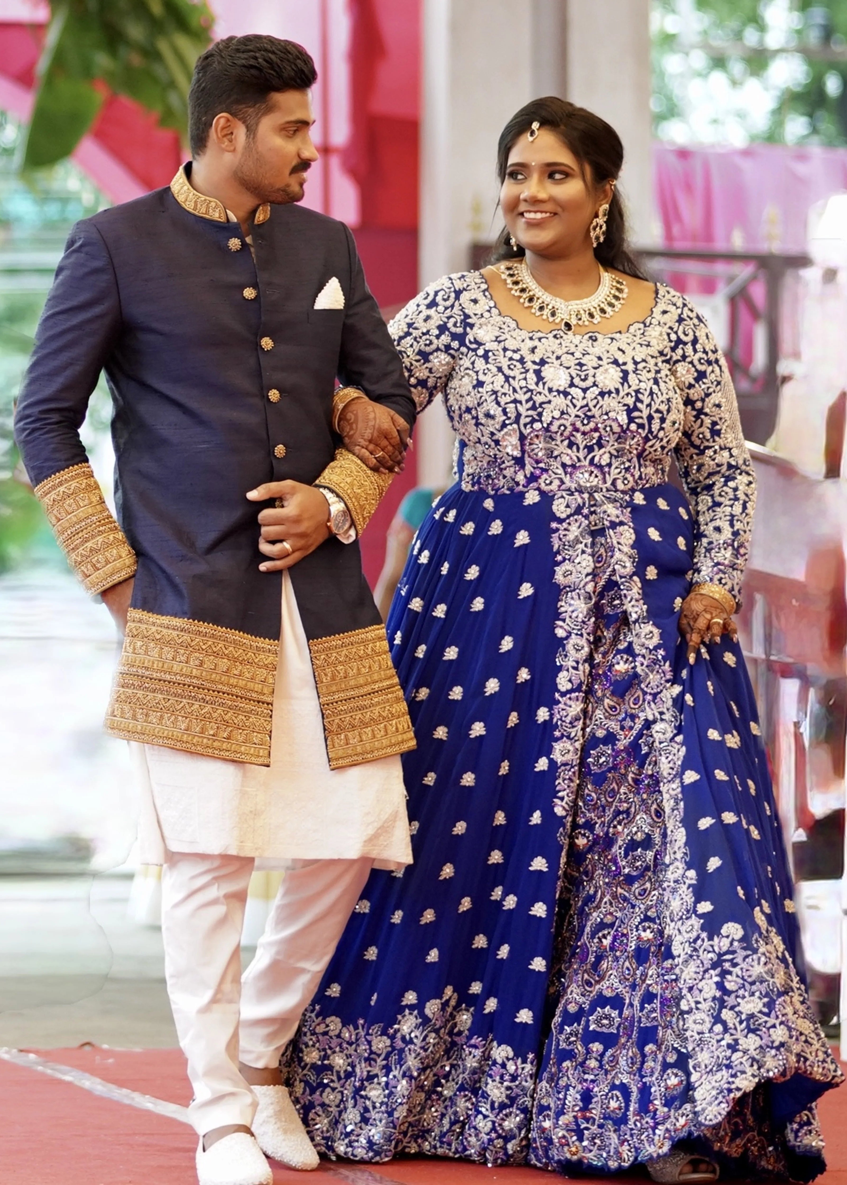 Bride & Groom from Dindigul, taking a stroll in a midnight blue handcrafted masakali lehenga and navy blue raw silk sherwani with embellished collar, cuffs and borders. Designed by Archana Karthick