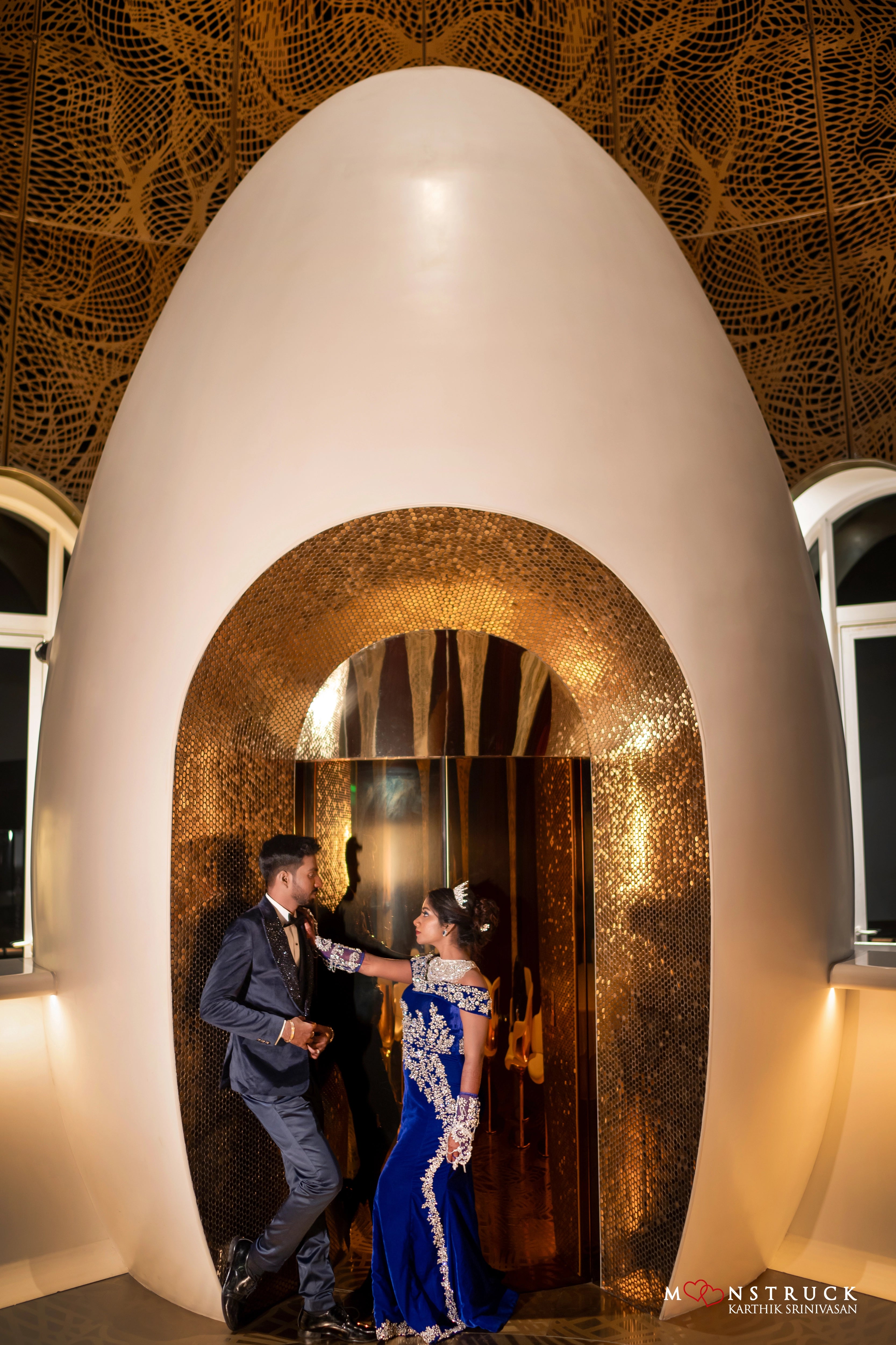 Bride Harsha posing with groom for shoot in a blue velvet gown by team Archana Karthick.