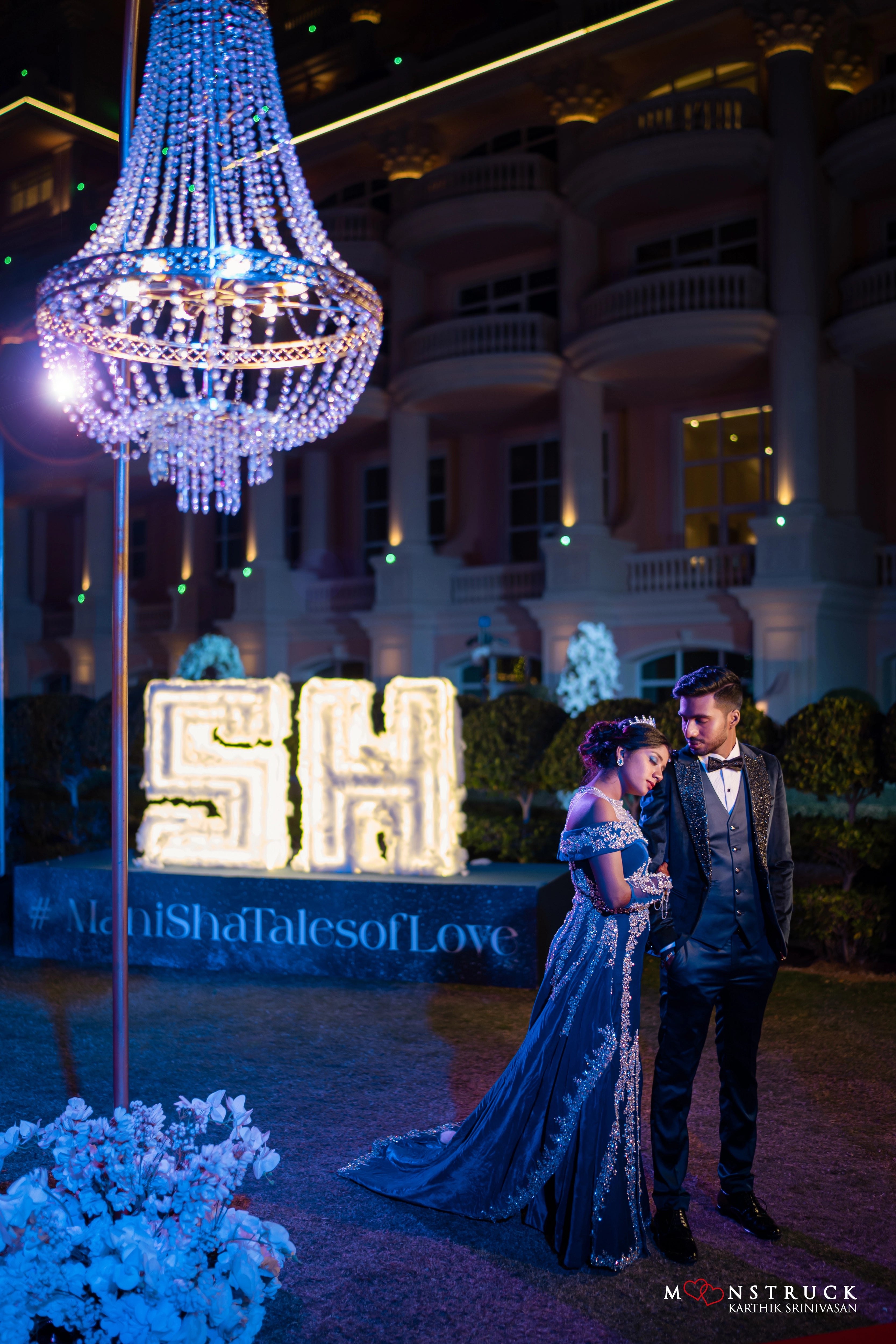 Bride Harsha posing with groom in a blue velvet gown by team Archana Karthick.