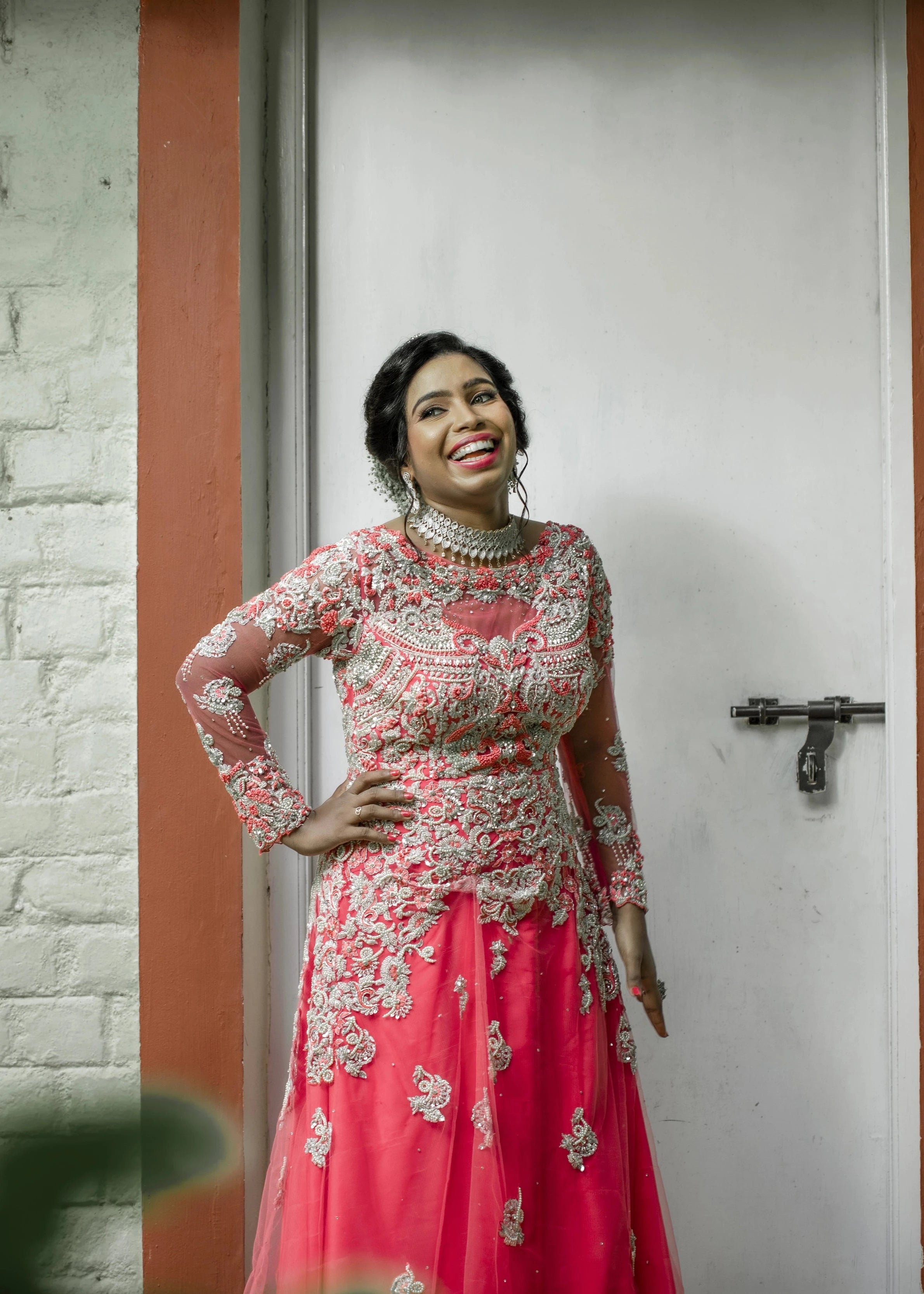 Bride Jayanthi smiling in a hot pink tulle gown, intricately handcrafted with beads, pearls, cutdana, stones, resham and zardozi by team Archana Karthick.