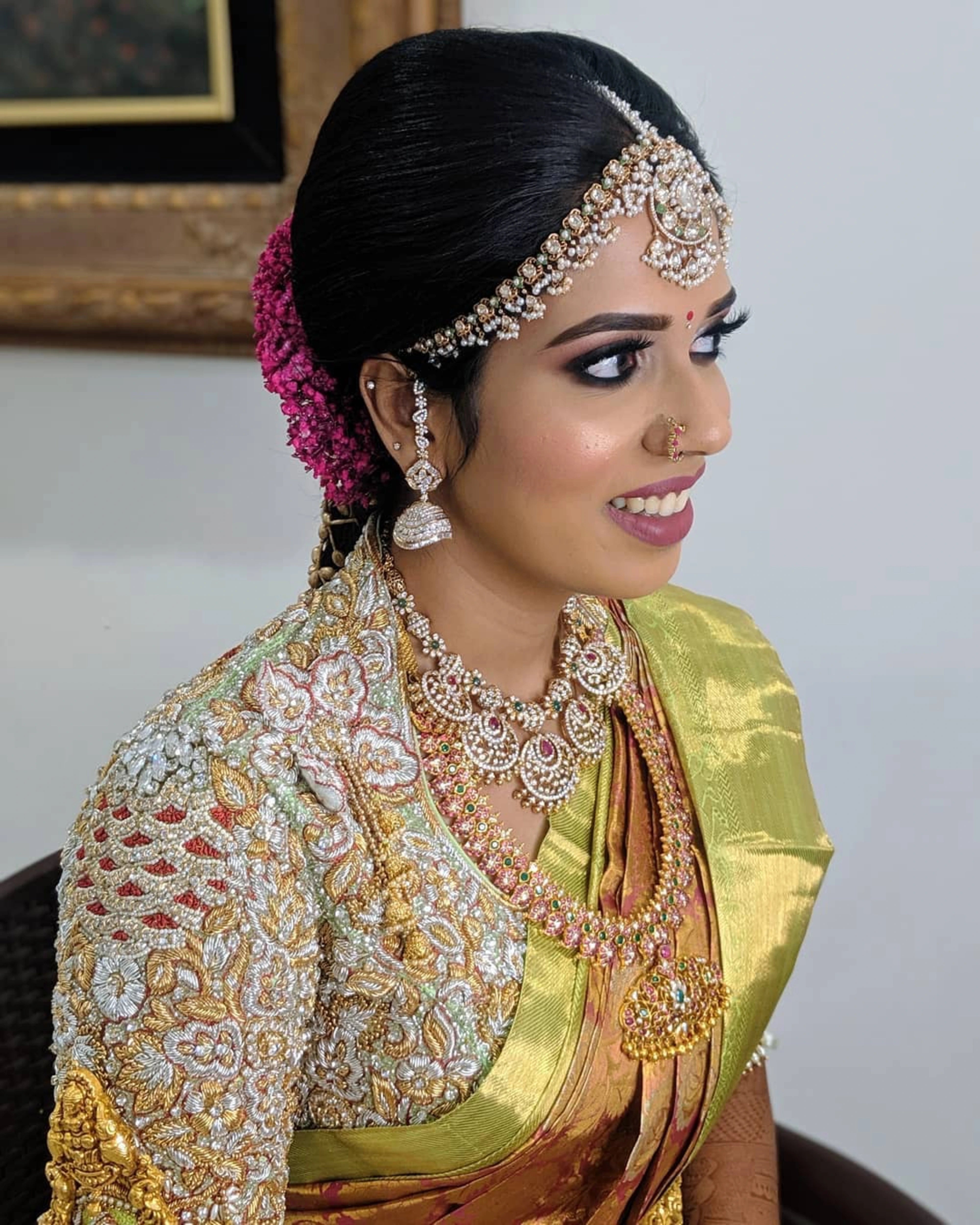 Bride Karthikeyani smiling in a pistachio green silk palanquin concept blouse for her wedding, handcrafted with zardozi, pearls, stones, etc by team Archana Karthick.