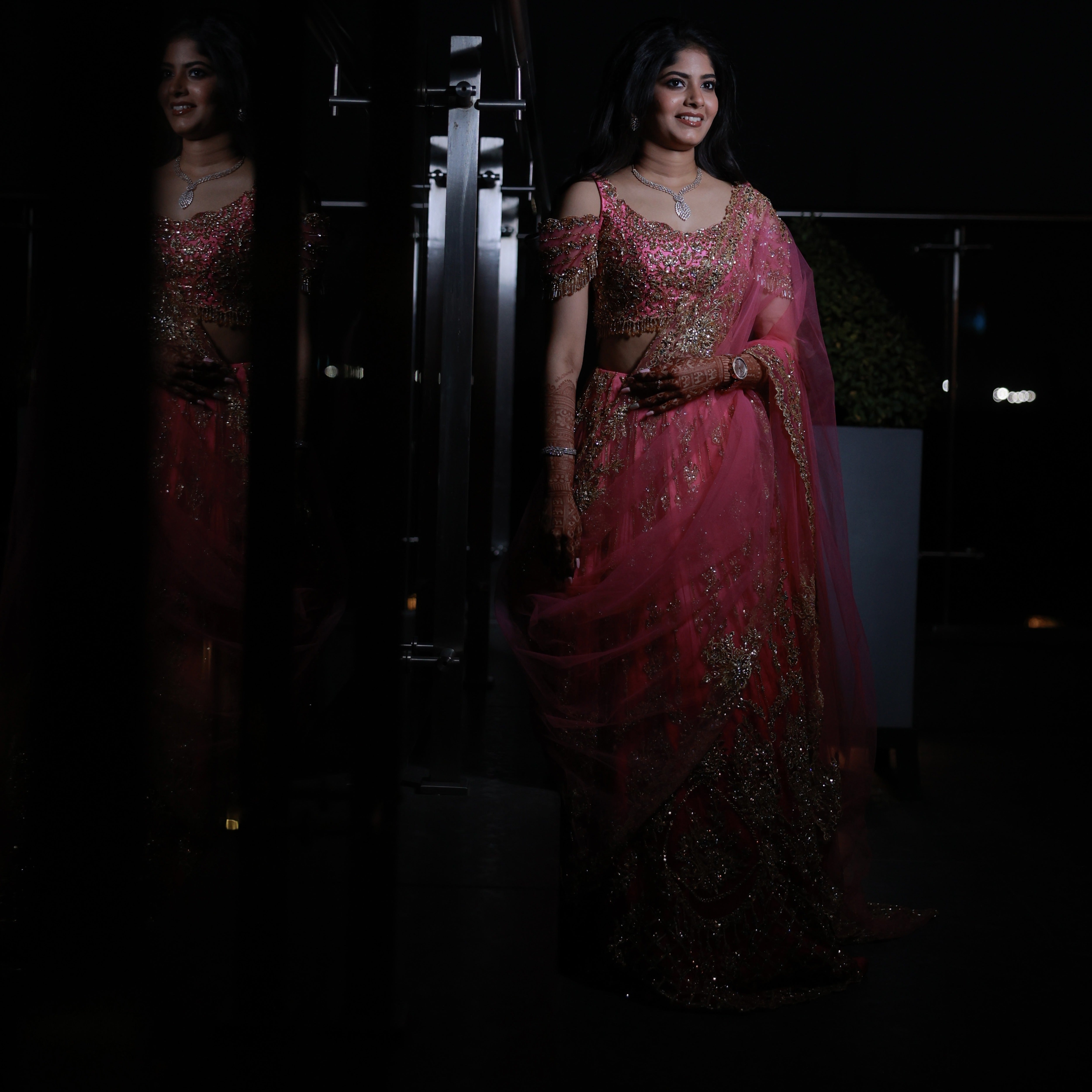 Bride Kaviya from Christchurch, New Zealand standing elegantly in the dark in her pink handcrafted reception lehenga with heavy stone work designed by Archana Karthick. Front blouse and dupatta design is captured well.