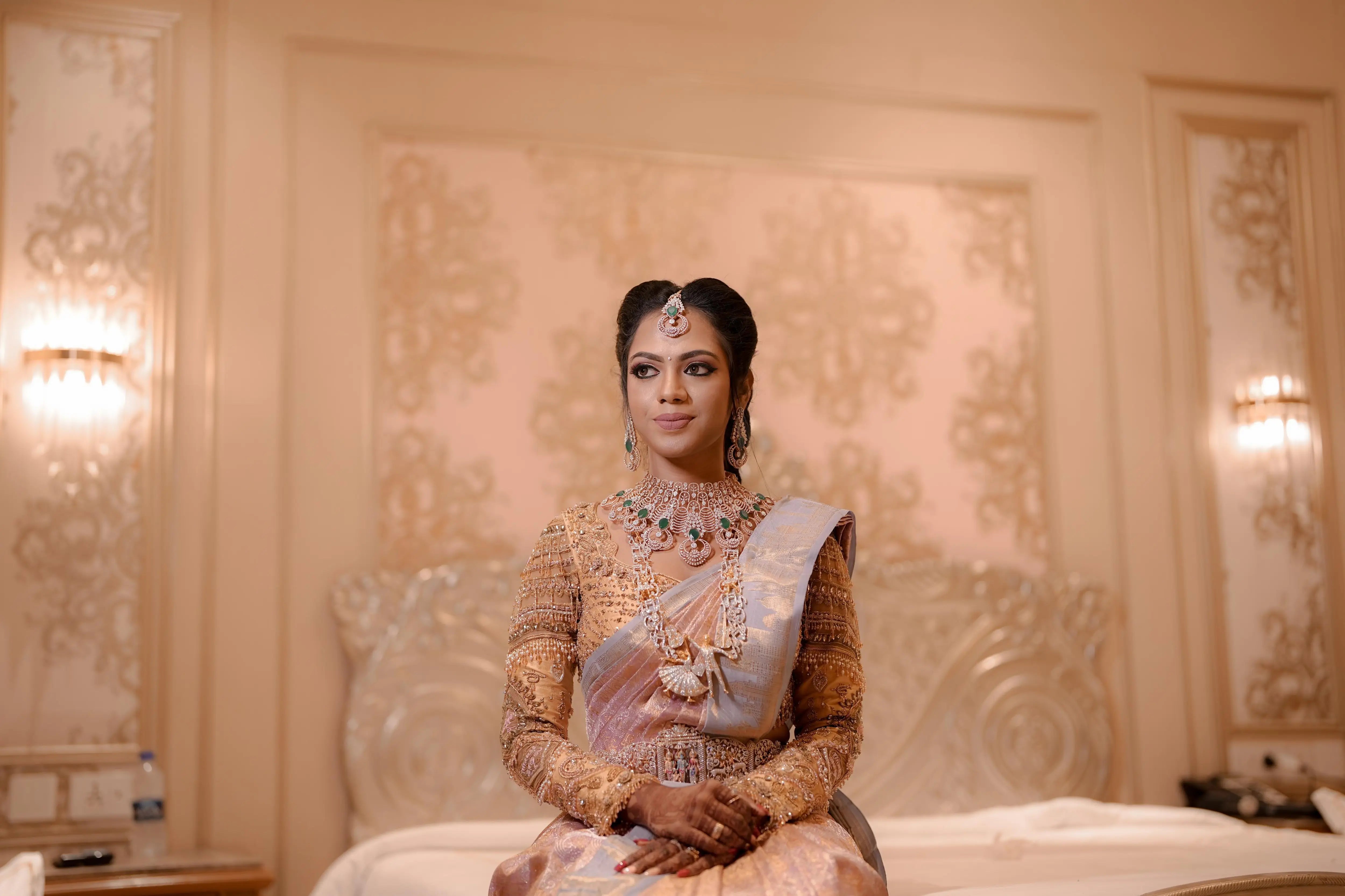 Bride Keerthiga from Chennai posing in a rose gold silk blouse by team Archana Karthick.