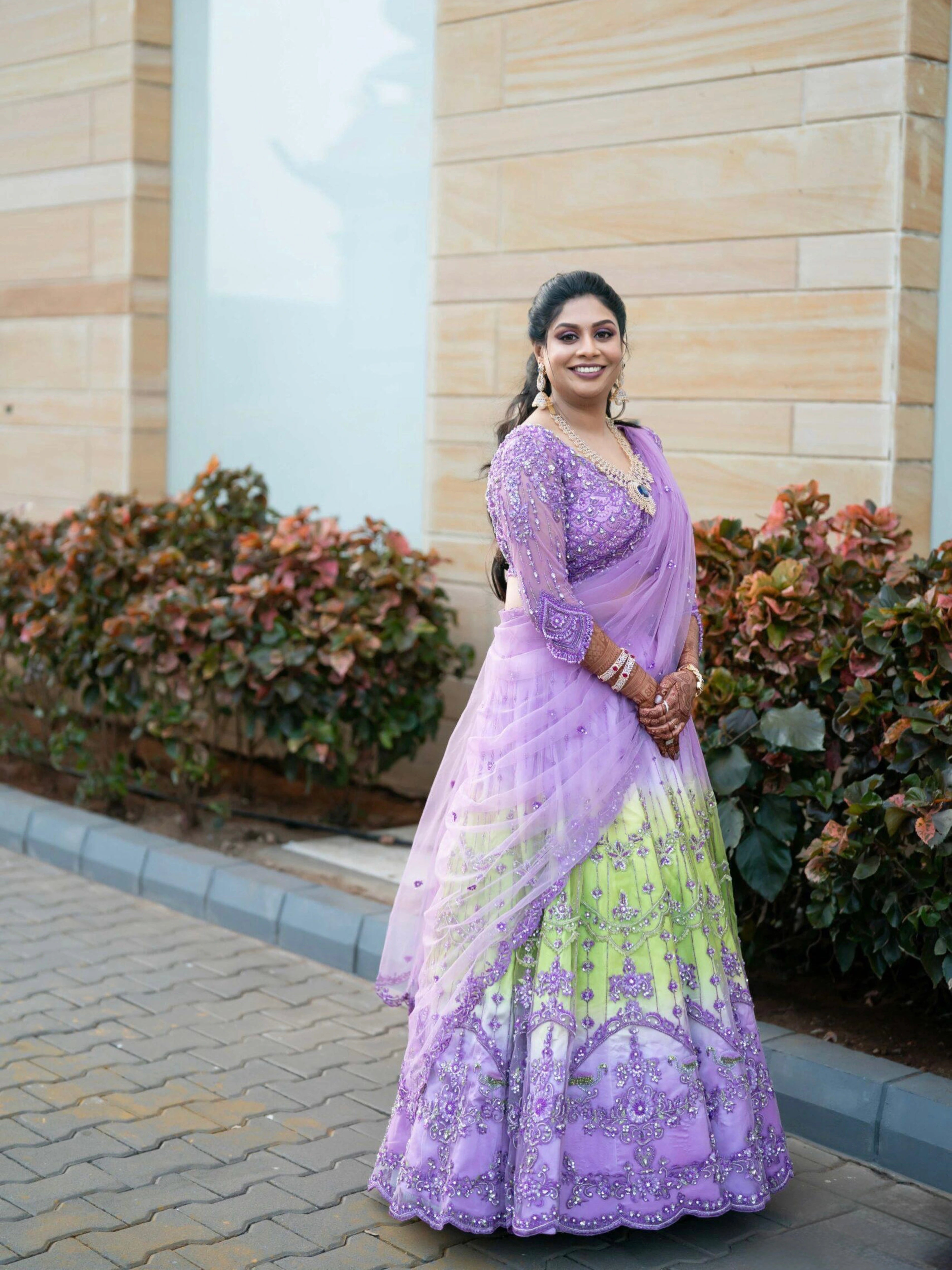 Bride Keerti smiling in a lavender & green tulle lehenga, intricately handcrafted with sequins, cutdana, beads, crystals, rhinestones & zardozi by team Archana Karthick