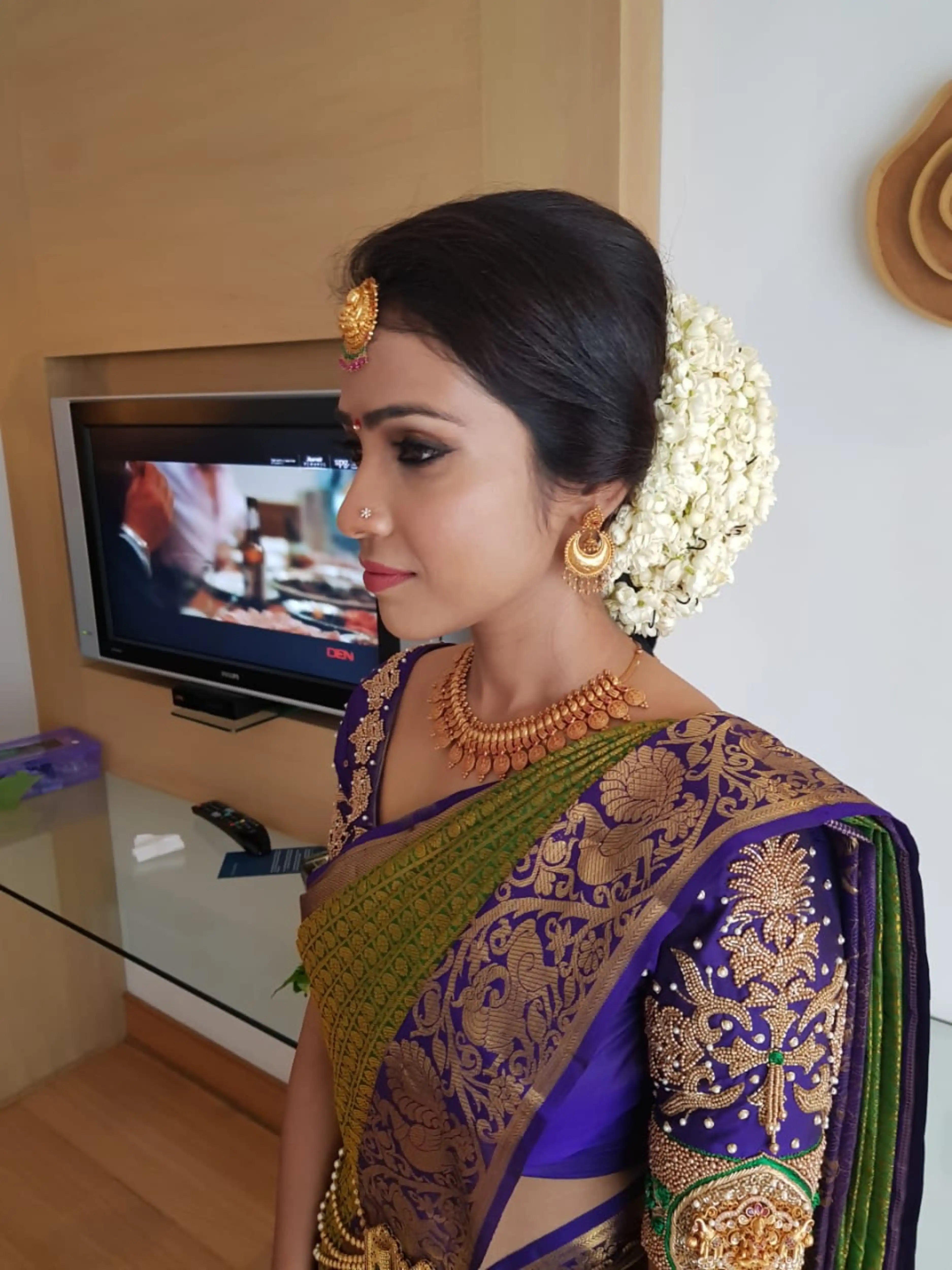 Bride Krishnapriya from Chennai posing in a blue silk blouse handcrafted intricately with beads, stones, resham and zardozi by team Archana Karthick.