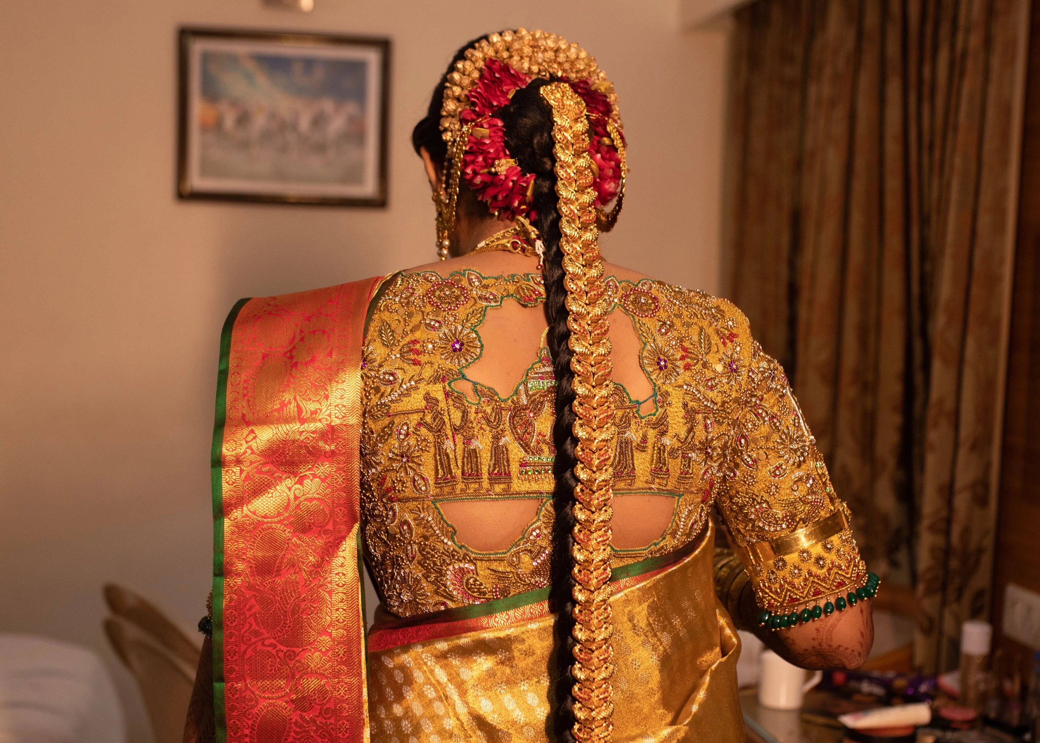 Bride Krithika Balan showing back blouse design in gold silk palanquin concept blouse, intricately handcrafted with zardozi, coins, resham, kemp stones and beads by team Archana Karthick.