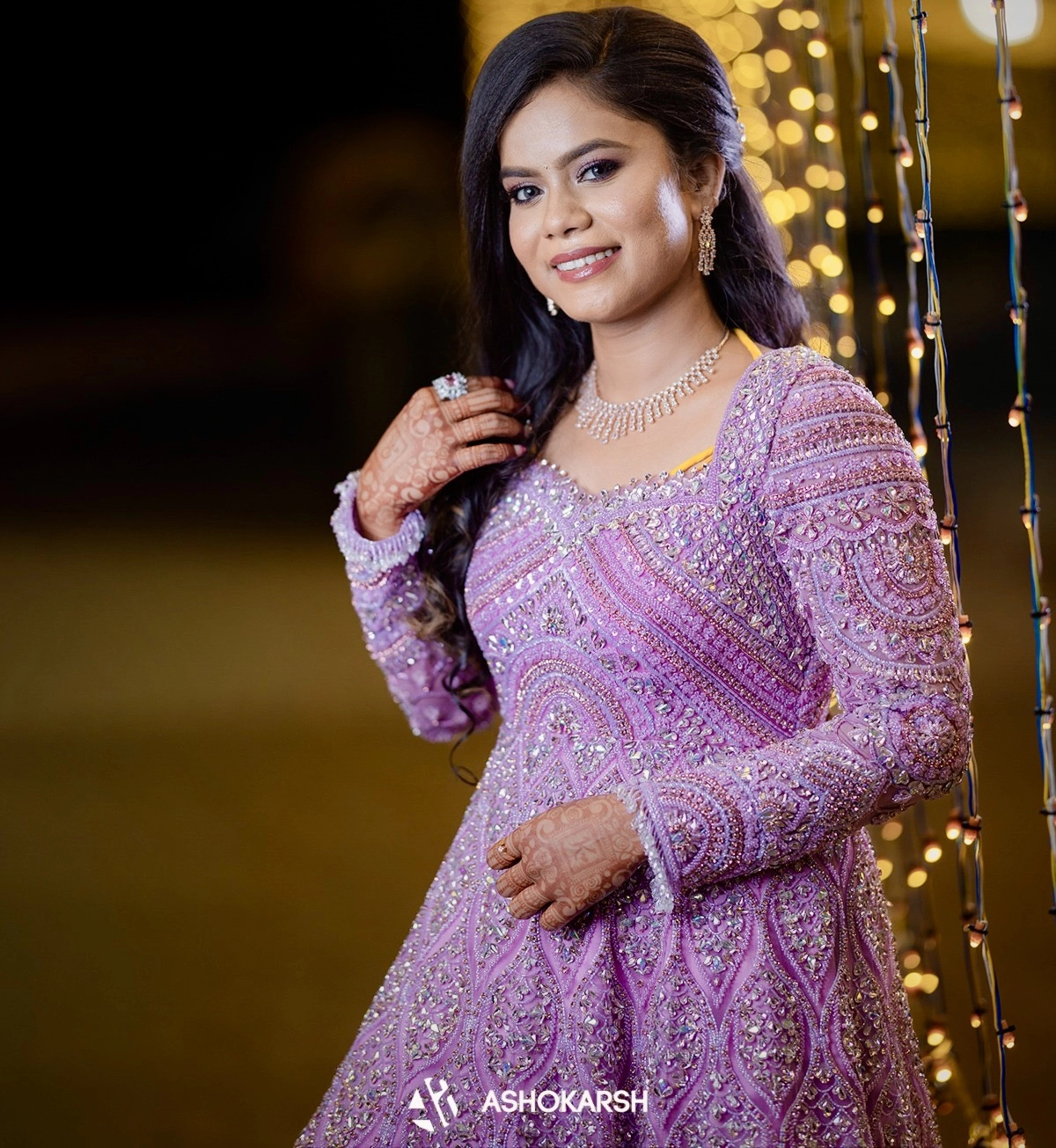 Bride Kushmma smiling for photo in a lilac pink ombre gown by team Archana Karthick