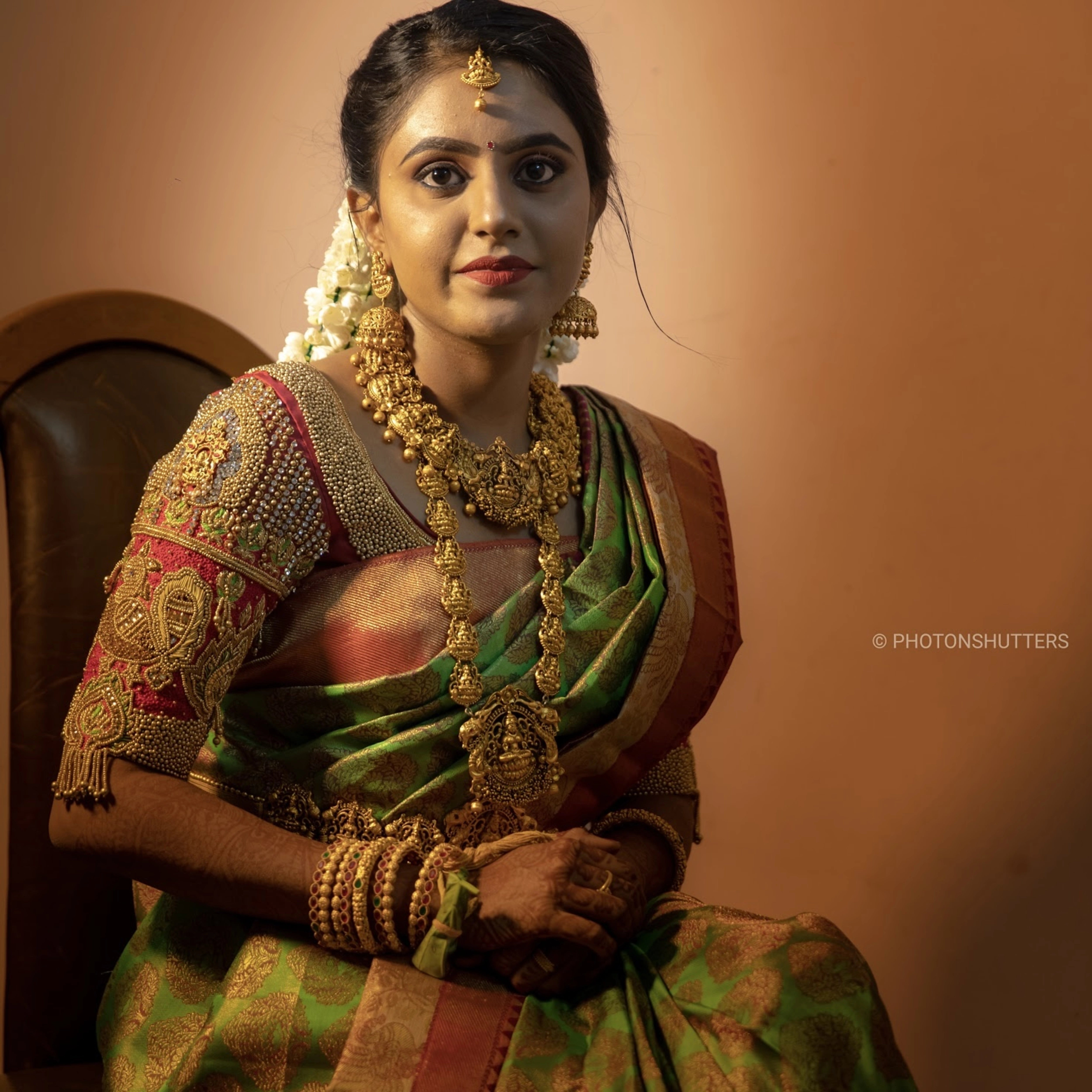 Bride Lavanya S in a handcrafted red silk blouse embellished with beads, zardozi, stones, beads, resham knot work & goddess pendants by team Archana Karthick.
