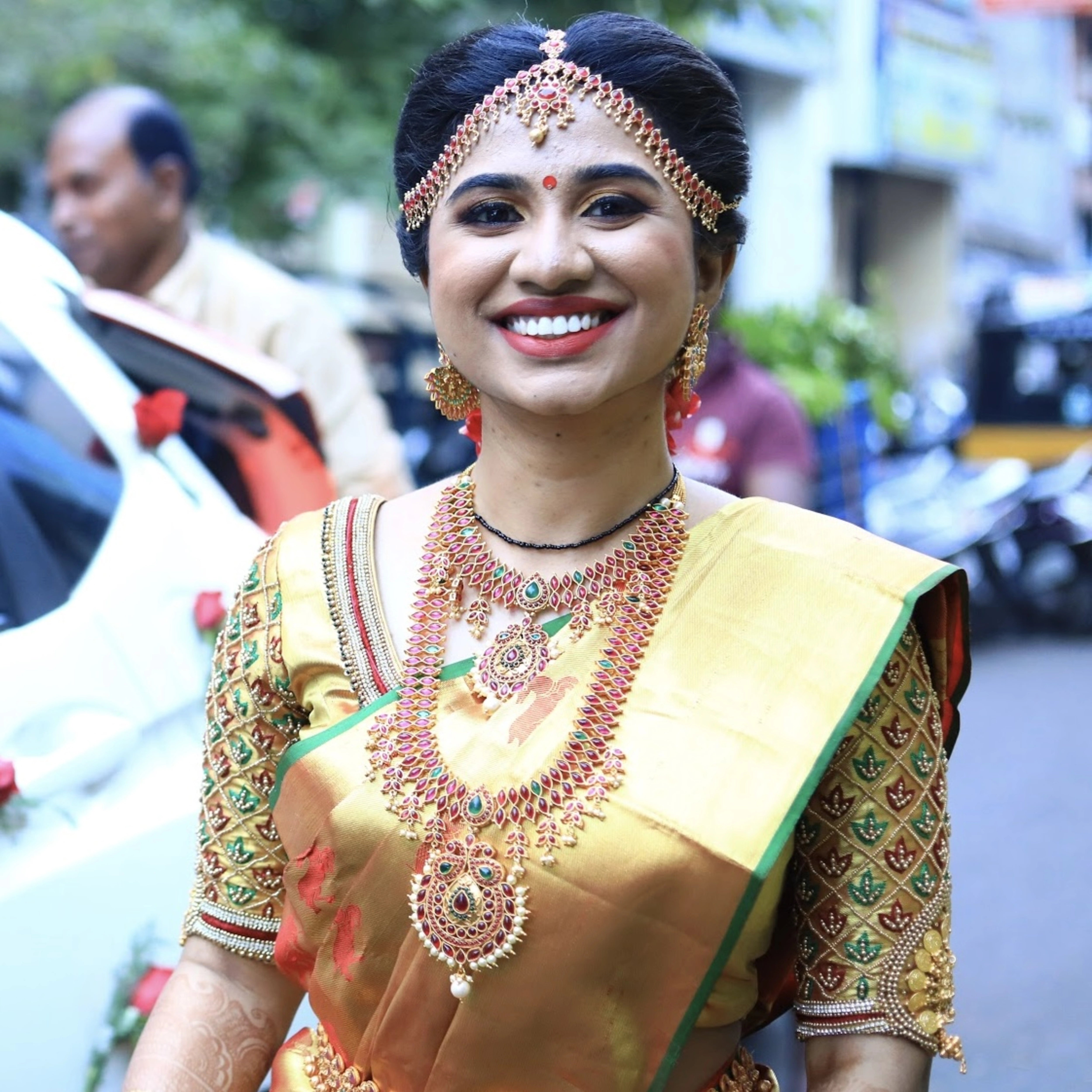 Bride Mahalakshmi, posing in a gold silk blouse handcrafted by team Archana Karthick.