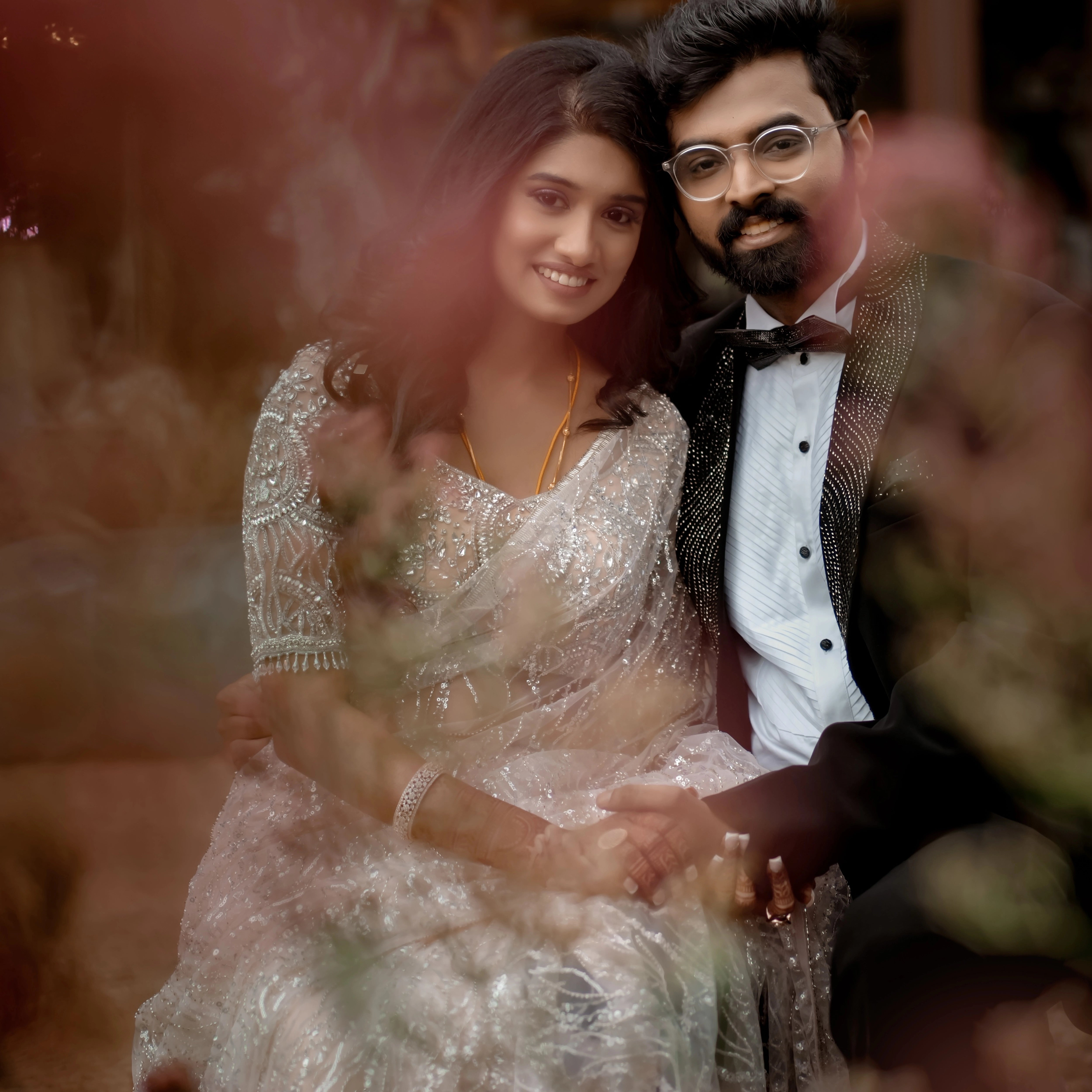 Bride Monica from USA posing with groom in a blush tulle blouse handcrafted by team Archana Karthick.