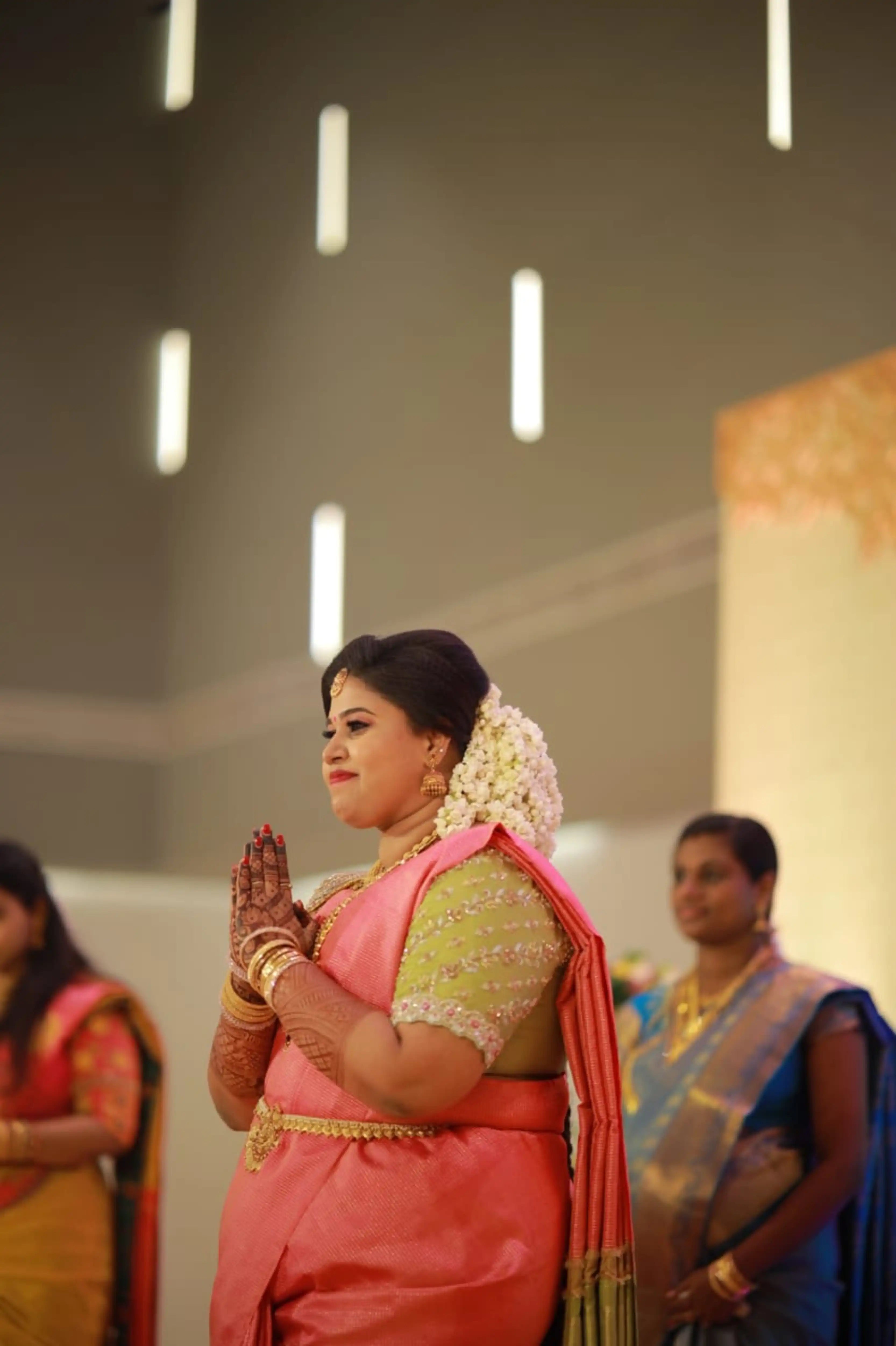 Bride Monisha from Kerala posing in a lime green silk blouse handcrafted by team Archana Karthick.