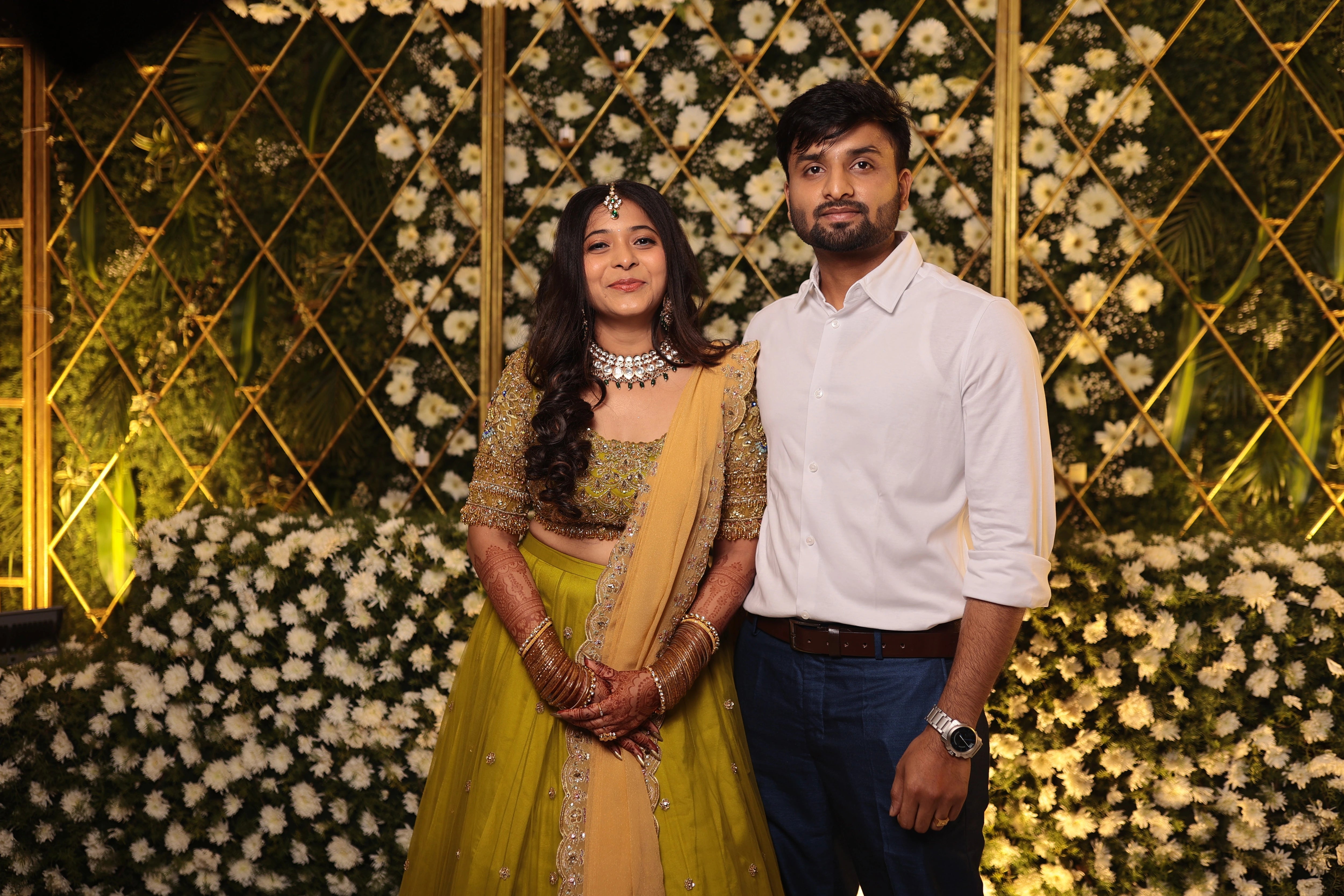Bride Nandita smiling with groom in a olive green tulle lehenga by team Archana Karthick.