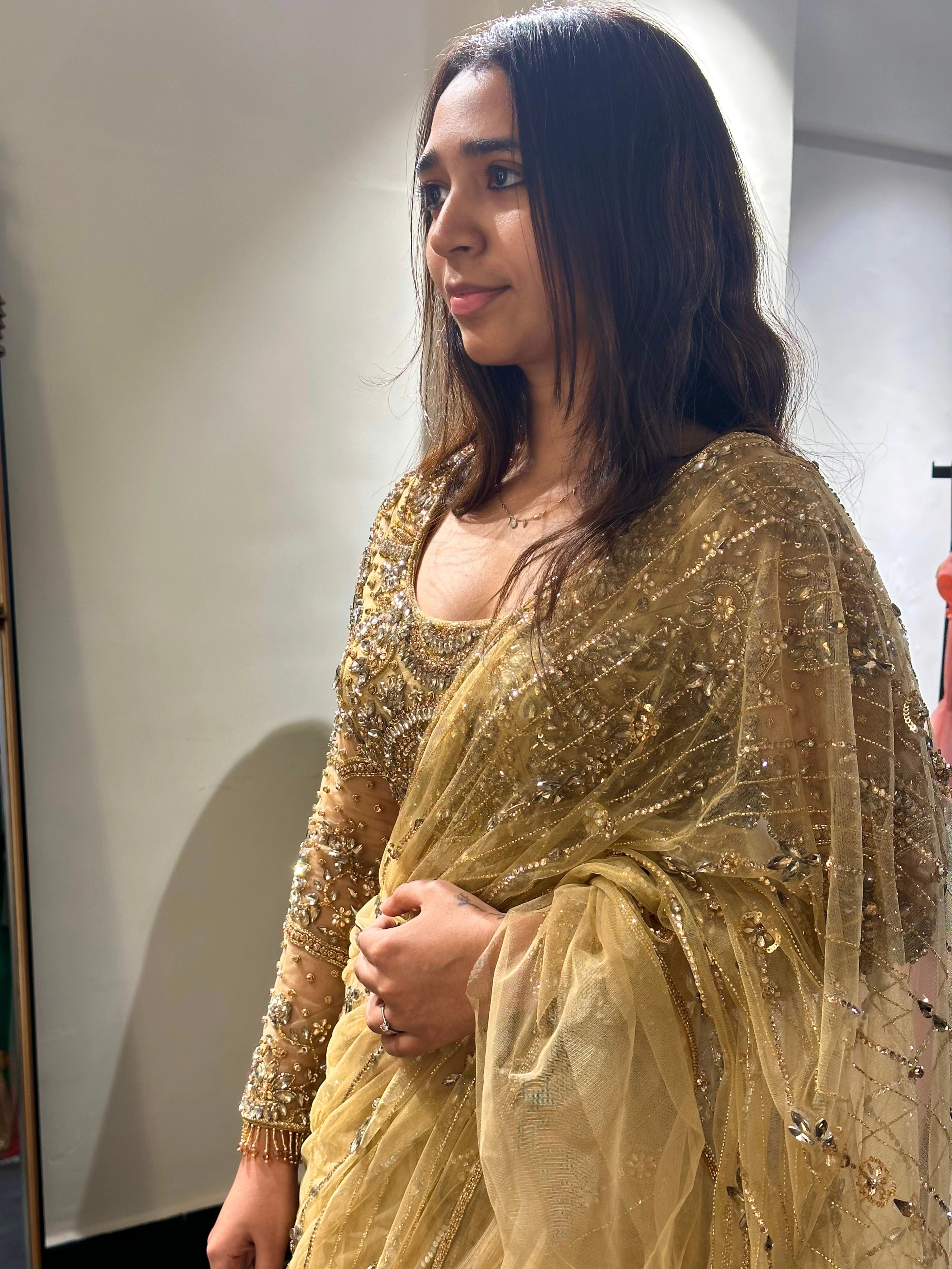 Bride Narmada posing during fittings in a golden beige tulle saree handcrafted by team Archana Karthick.