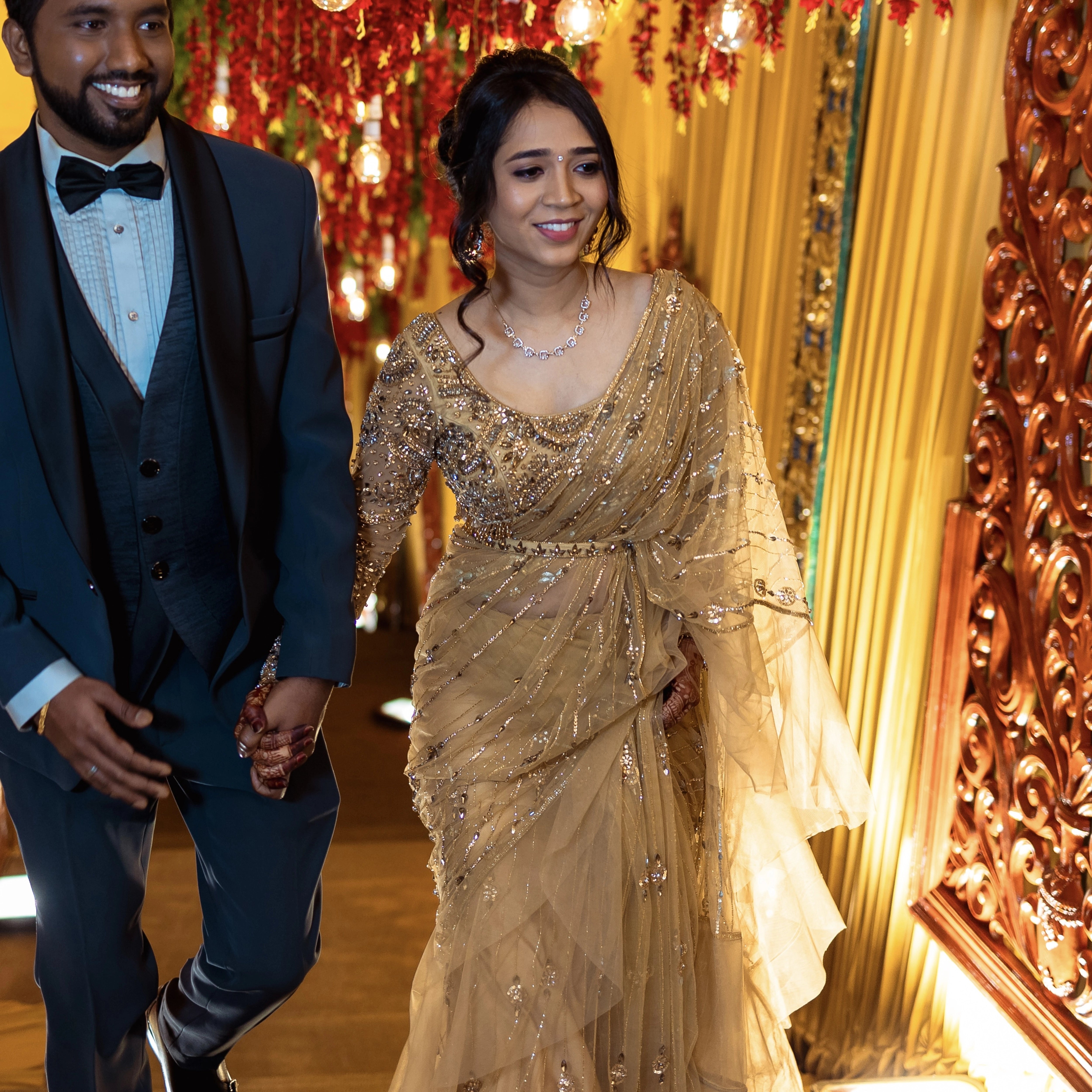 Bride Narmada posing with groom in a golden beige tulle saree handcrafted by team Archana Karthick.