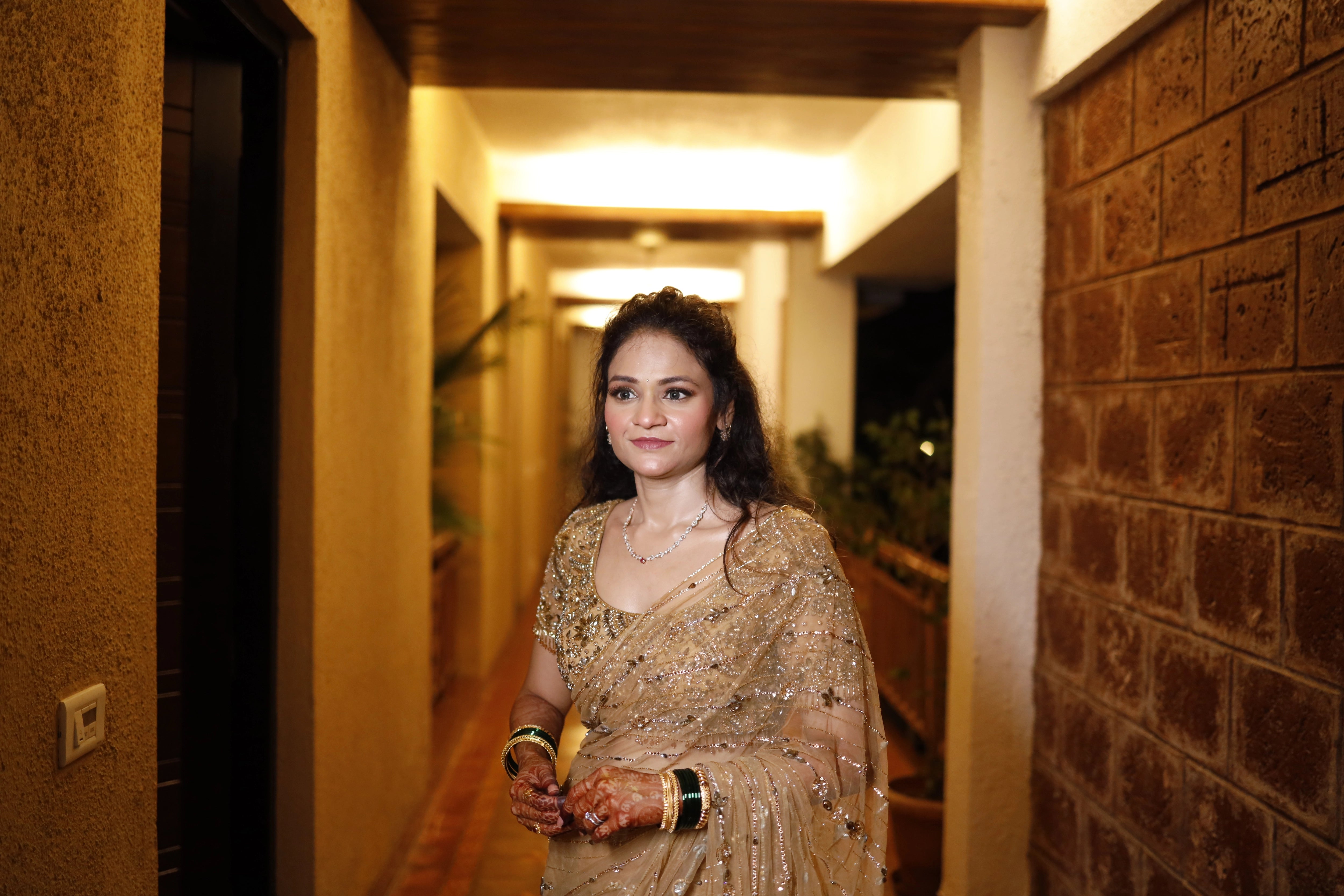 Bride Neha from Virginia, in a golden tulle saree, handcrafted with rhinestones, zardozi, sequins, crystals, cutdana and stones by team Archana Karthick.