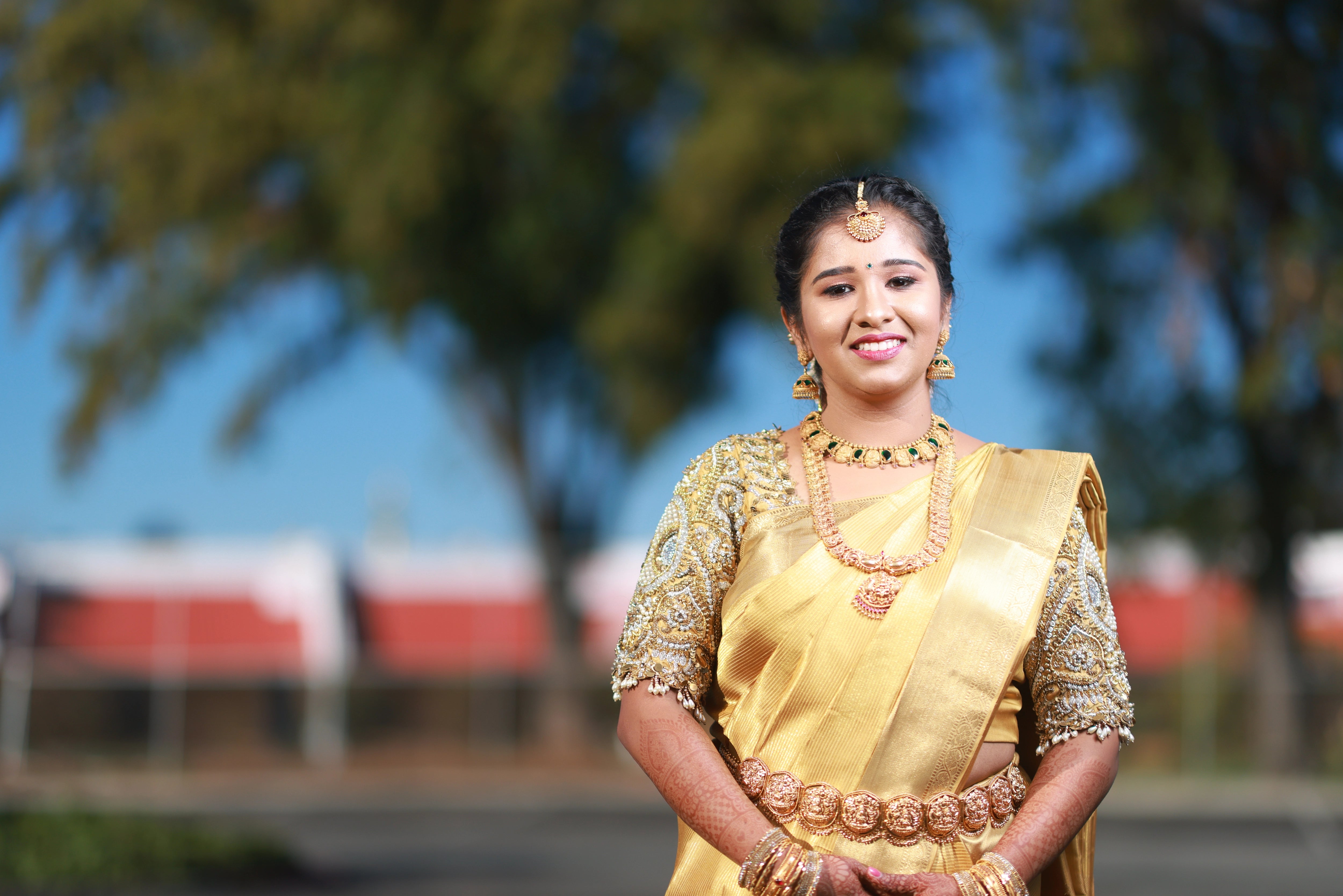 Bride Niveda in a gold silk blouse handcrafted by team Archana Karthick.
