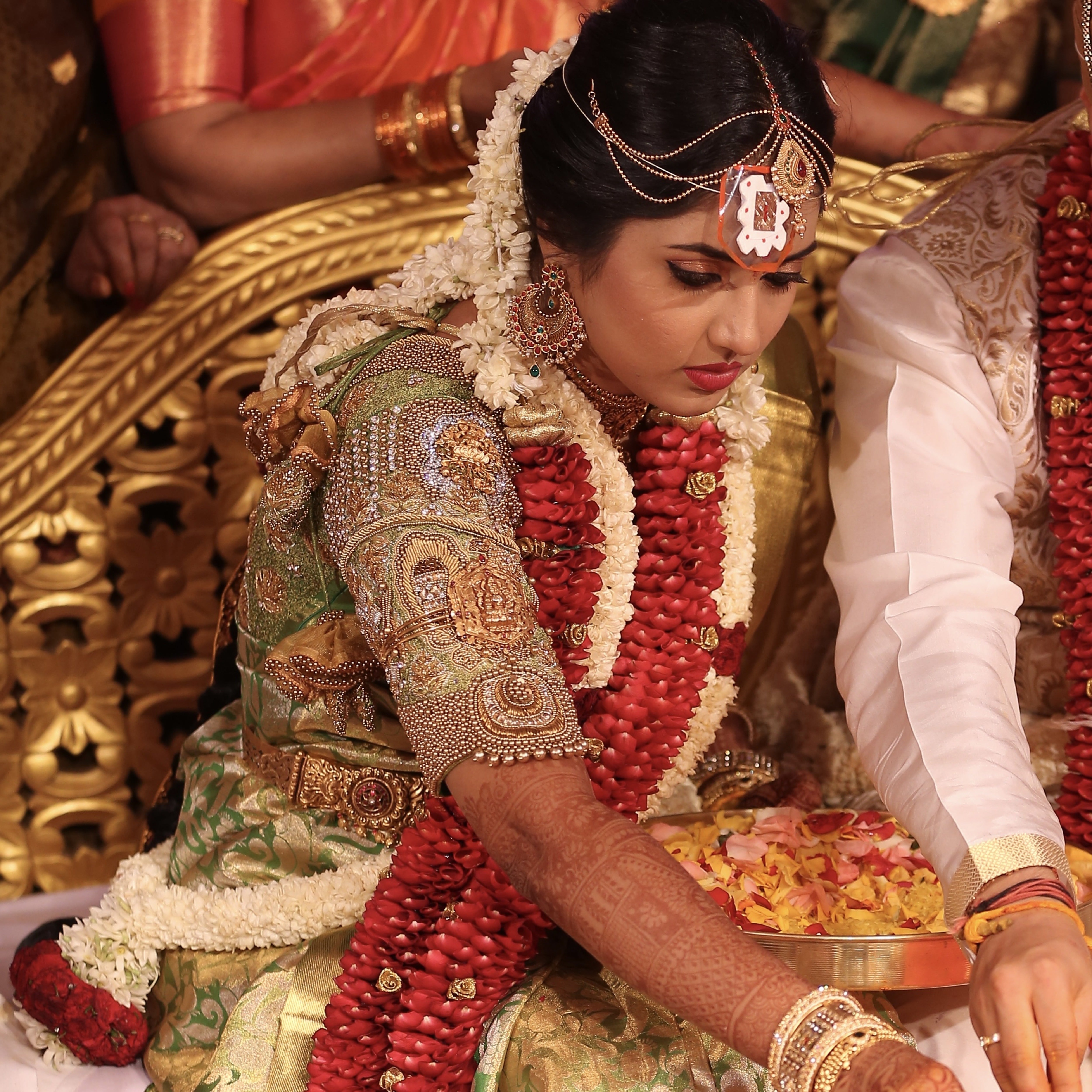 Bride Nivetha during ritual in a lemon green silk blouse, intricately handcrafted with zardozi, beads, stones, nakshi and more by team Archana Karthick.