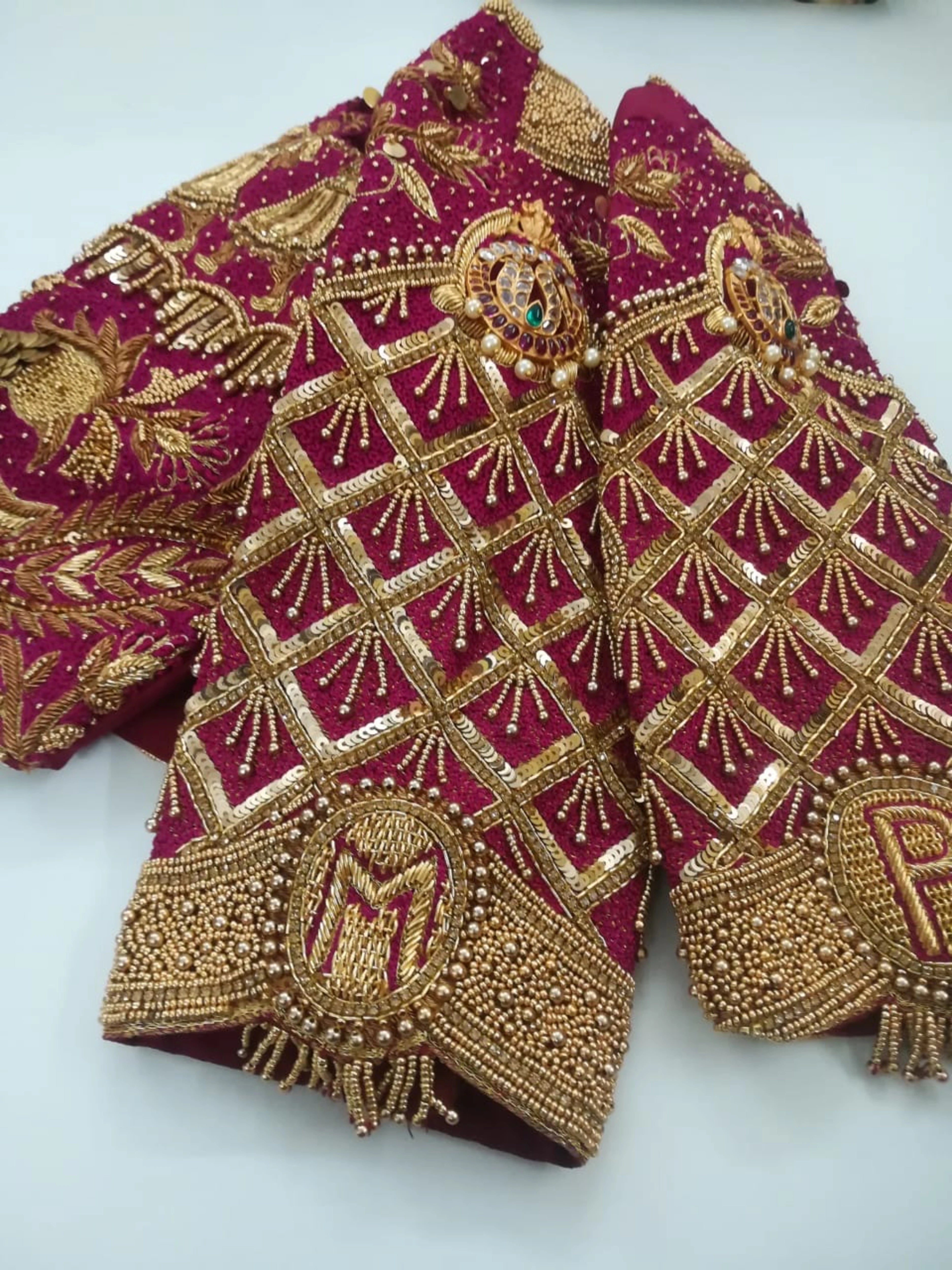 Bride Padma from Coimbatore showcasing sleeves in a red silk palanquin concept blouse intricately handcrafted with zardozi, stones, beads, sequins etc by team Archana Karthick.
