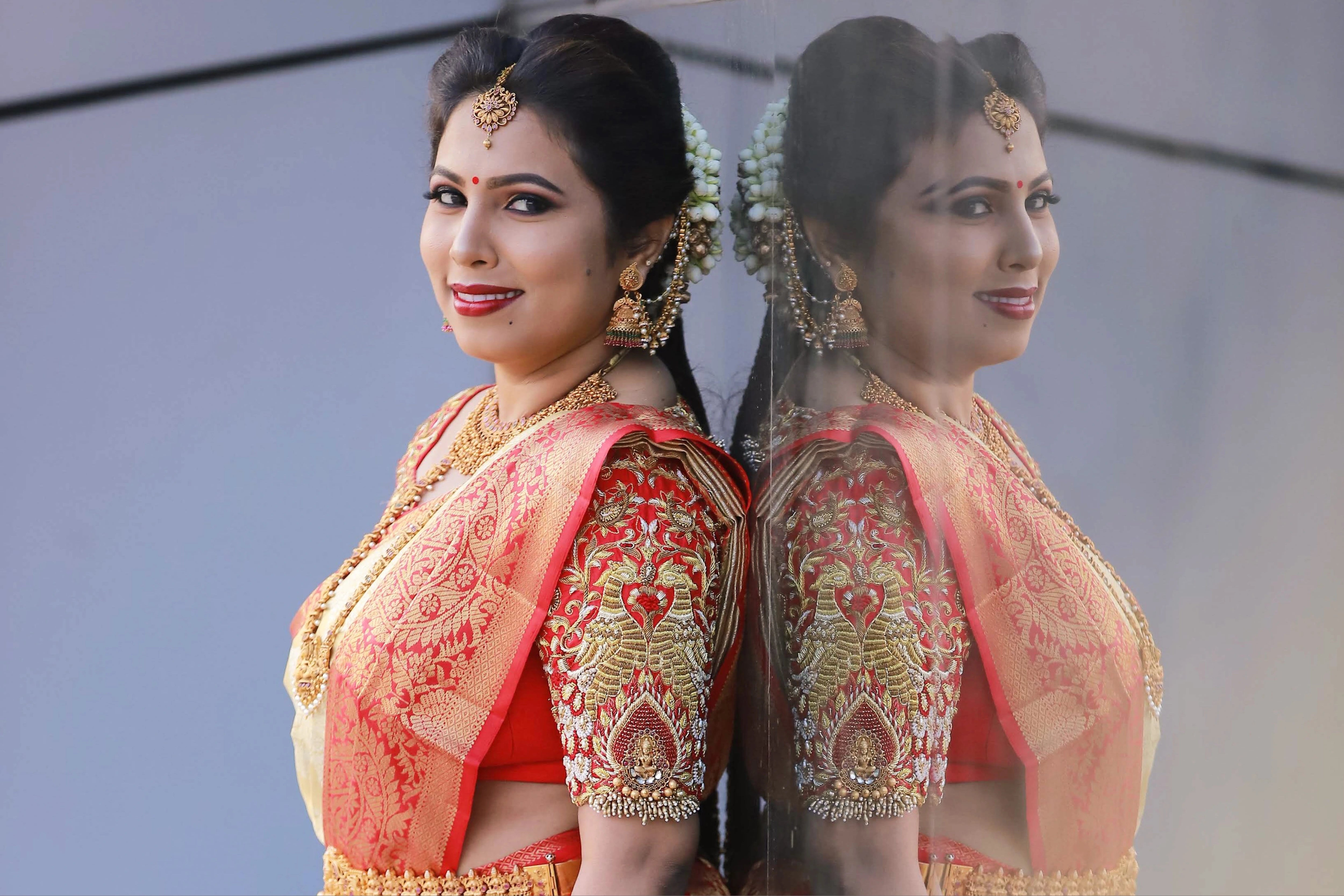 Bride Pooja from Bangalore in a red silk blouse handcrafted by team Archana Karthick.