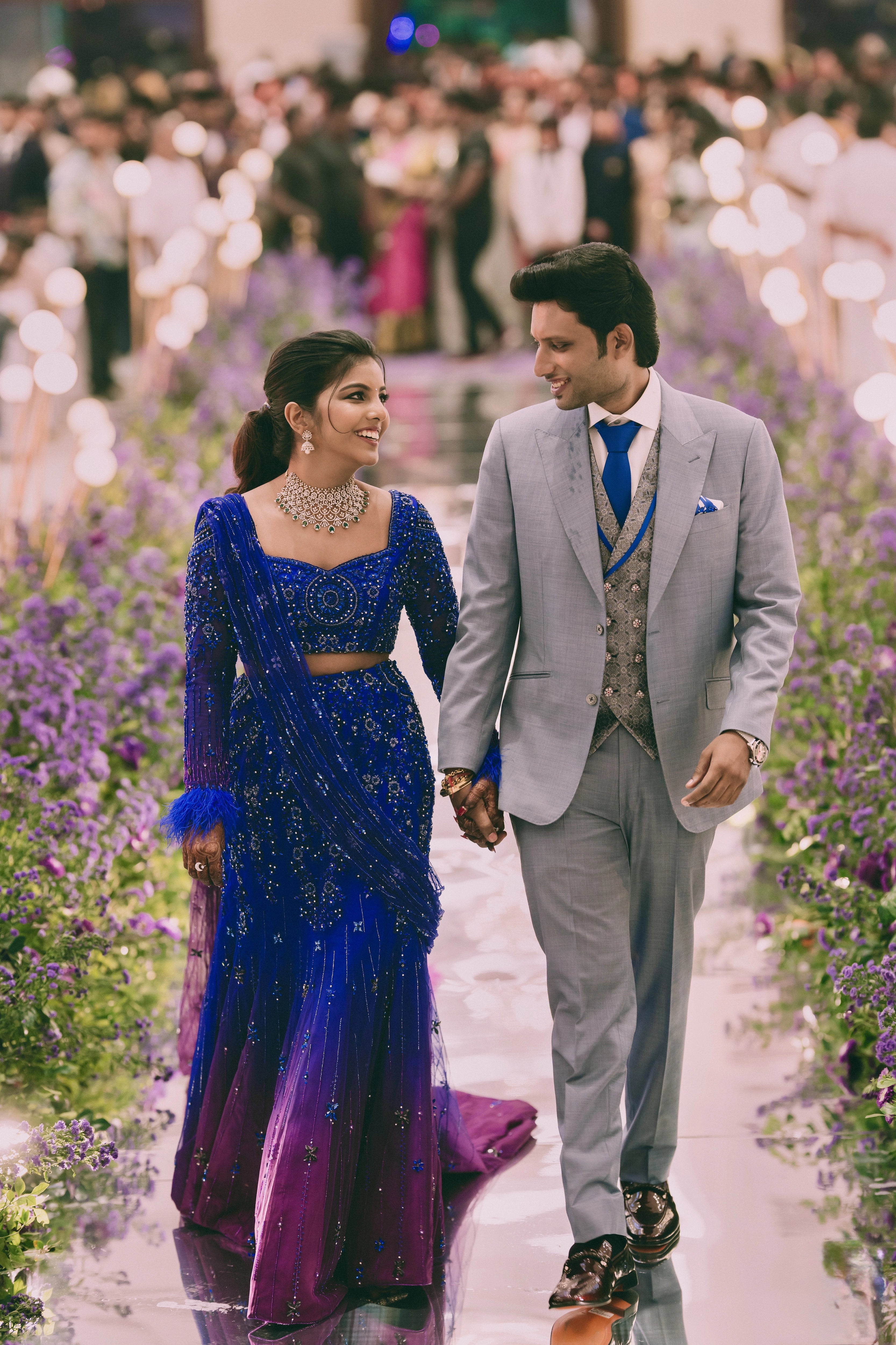 Bride Pooja with groom in a blue and purple mermaid draped lehenga by team Archana Karthick.