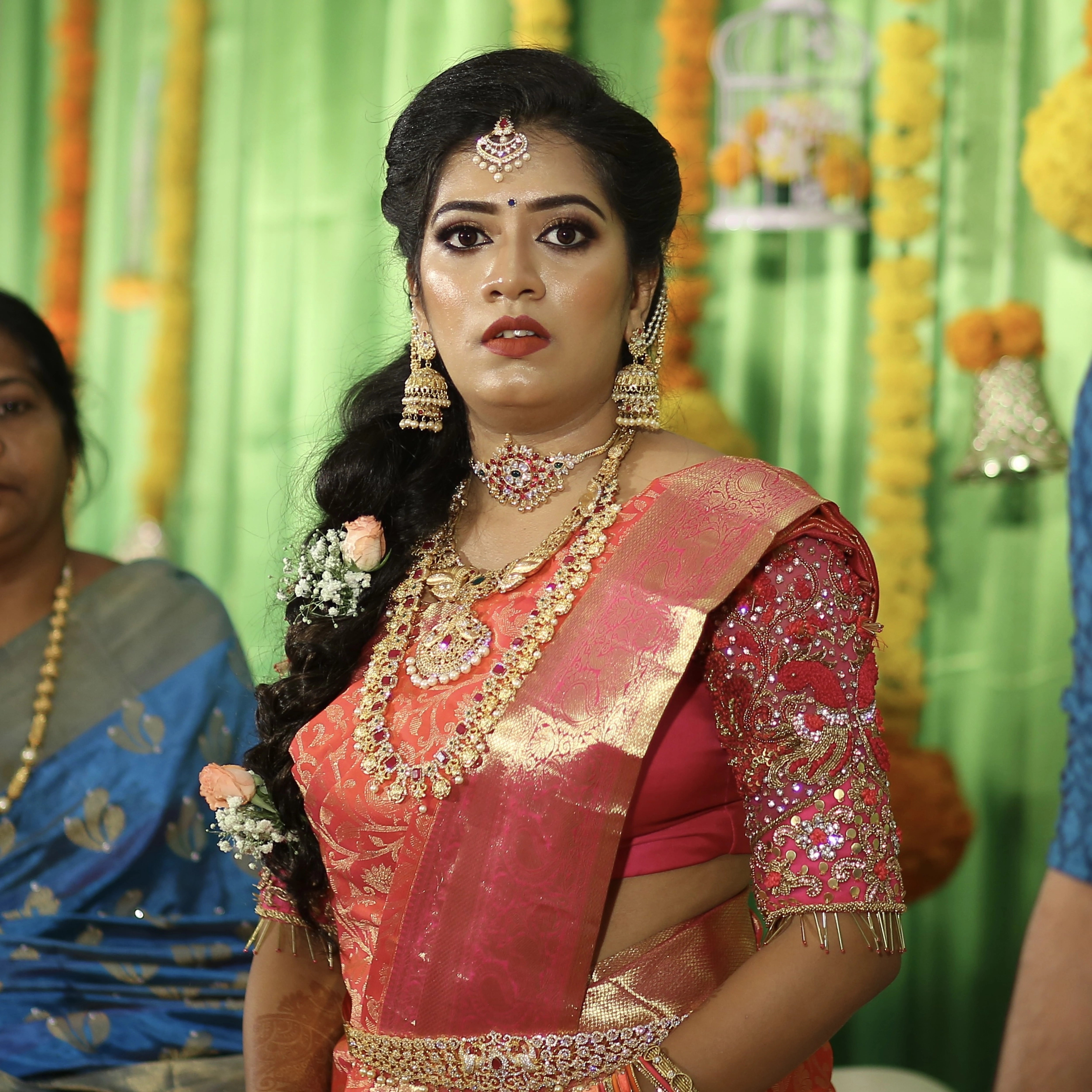 Bride Preethi Shiva posing in a pink silk blouse handcrafted by team Archana Karthick.