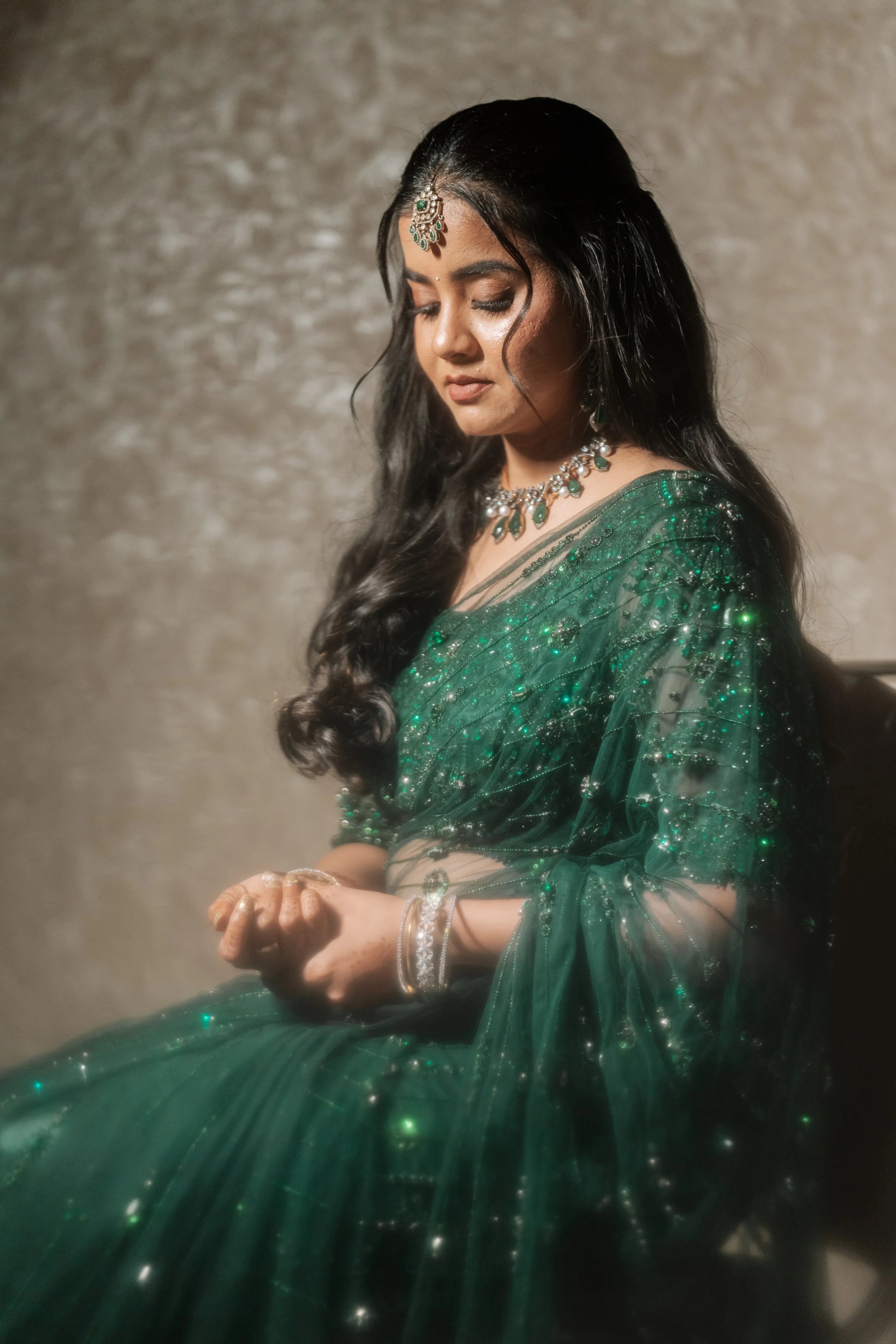 Bride Priyanka in a bottle green tulle saree, intricately handcrafted with rhinestones, zardozi, sequins, crystals, cutdana and stones by team Archana Karthick.