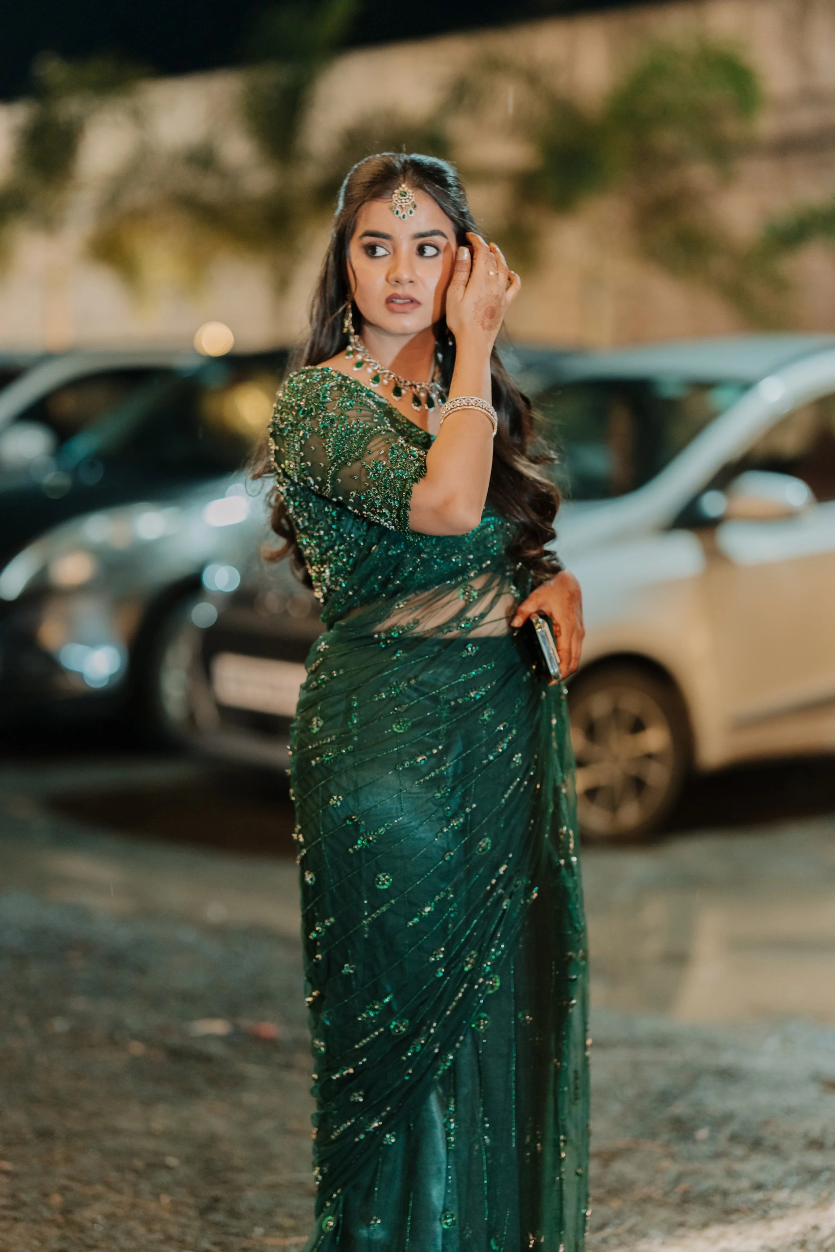 Bride Priyanka posing in a photoshoot in a bottle green tulle saree, intricately handcrafted with rhinestones, zardozi, sequins, crystals, cutdana and stones by team Archana Karthick.