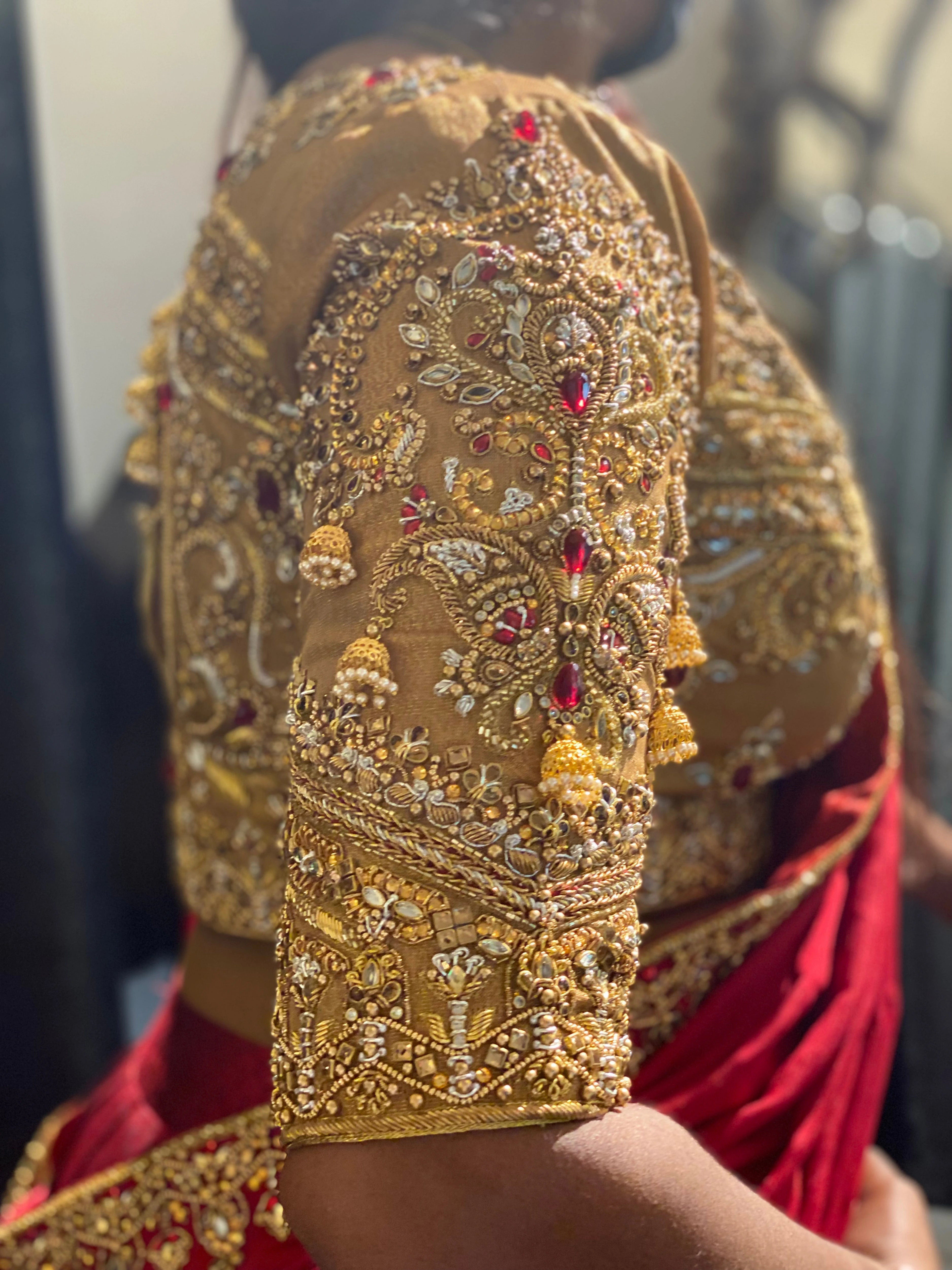 Bride Raji from Ireland during fittings in a red and gold silk half saree handcrafted by team Archana Karthick