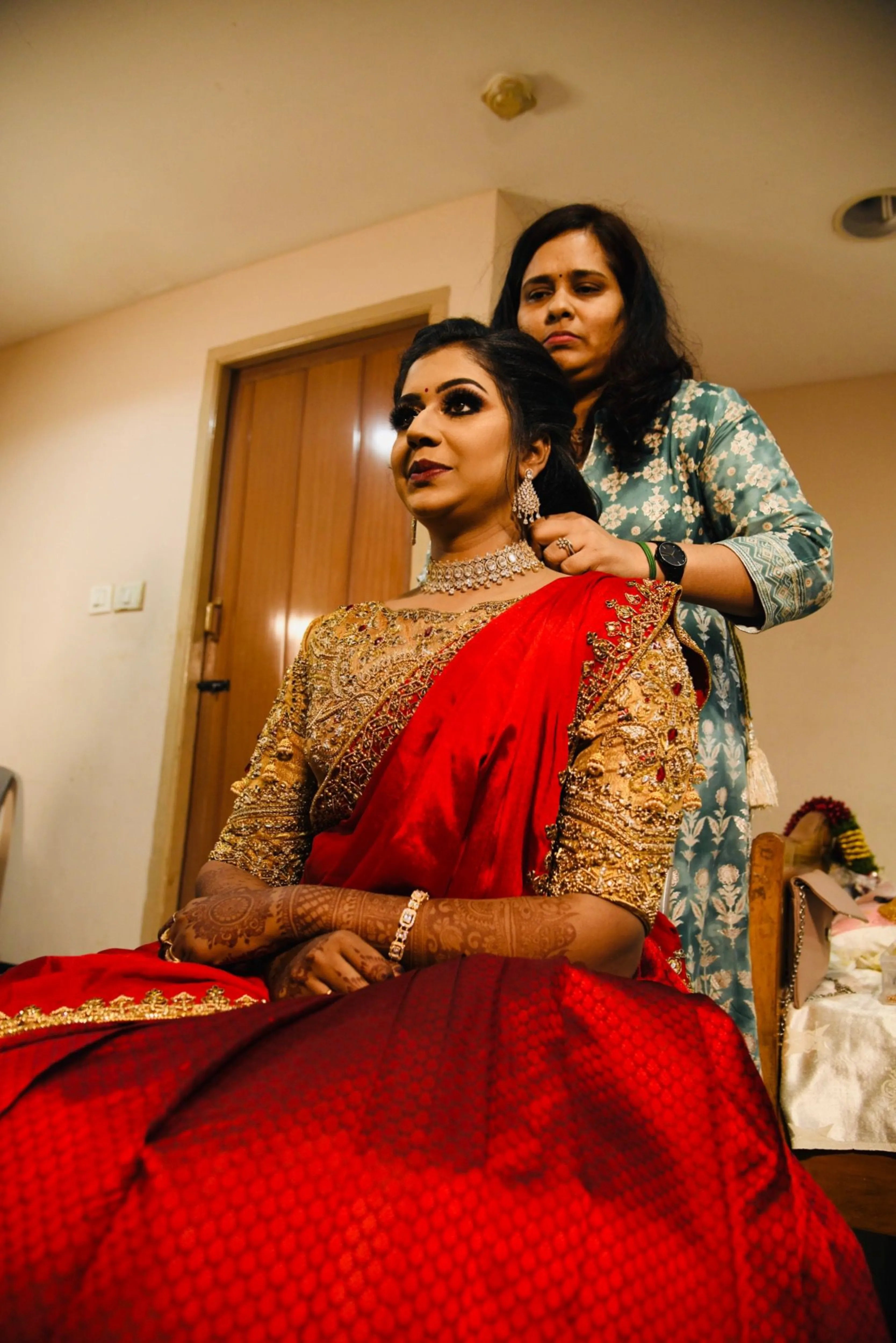 Bride Raji from Ireland in a red and gold silk half saree, handcrafted intricately with stones, zardozi, beads, sequins and rhinestones by team Archana Karthick