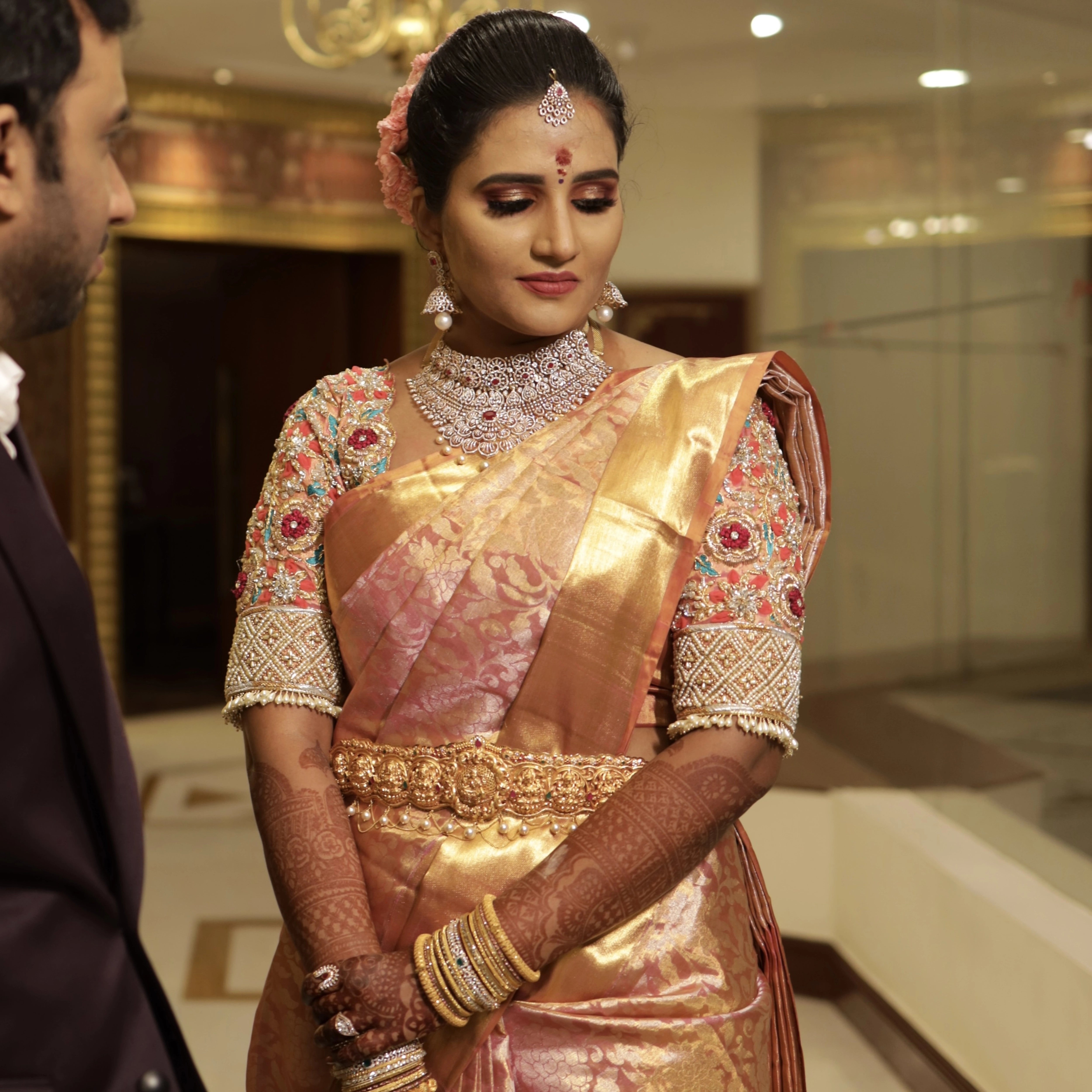 Bride Ramya from Chennai posing in a soft blush tissue concept blouse for her wedding, handcrafted with zardozi, stones, pearls, resham and cutdana by Archana Karthick.