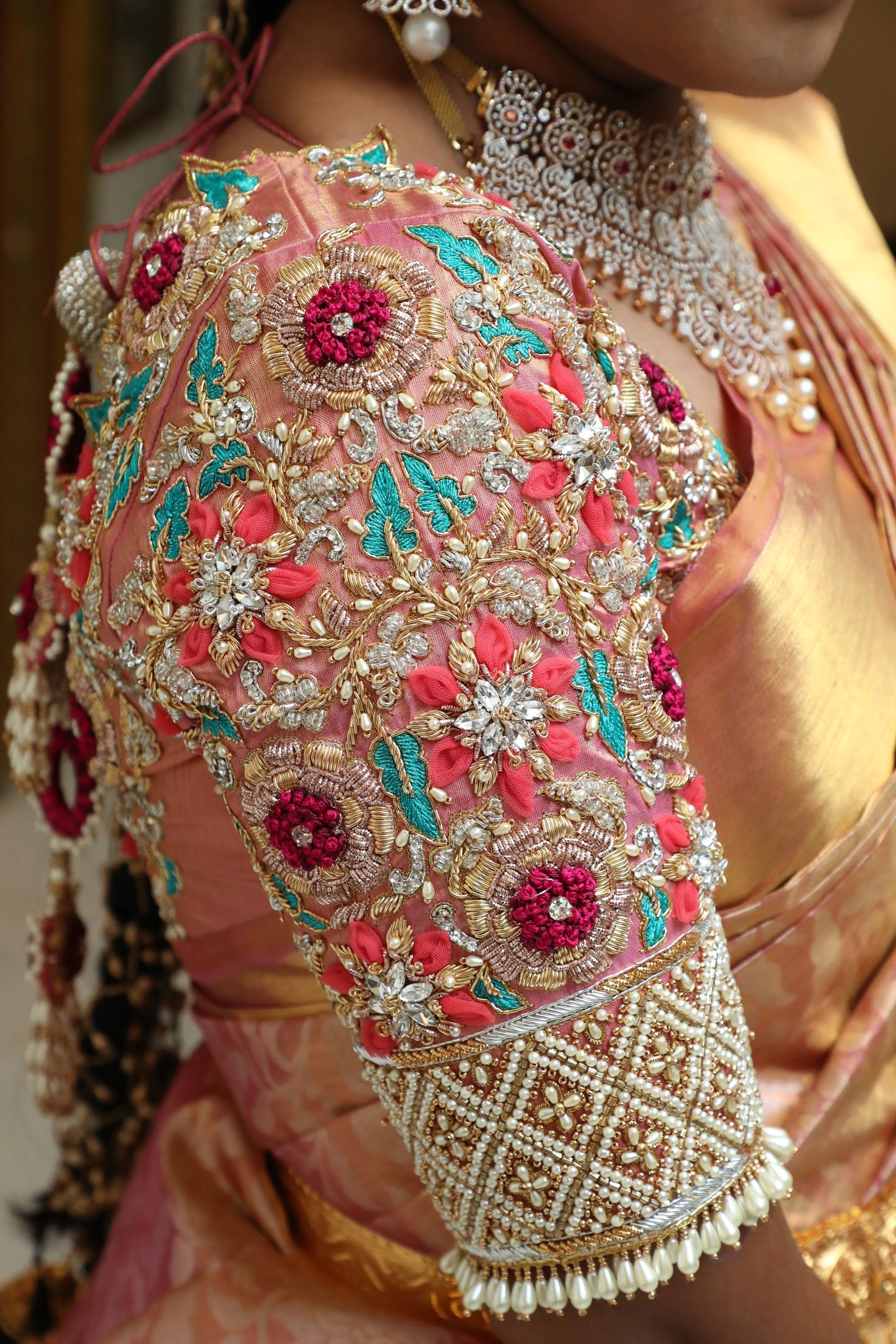 Bride Ramya from Chennai showcasing sleeve in a soft blush tissue concept blouse for her wedding, handcrafted with zardozi, stones, pearls, resham and cutdana by Archana Karthick.