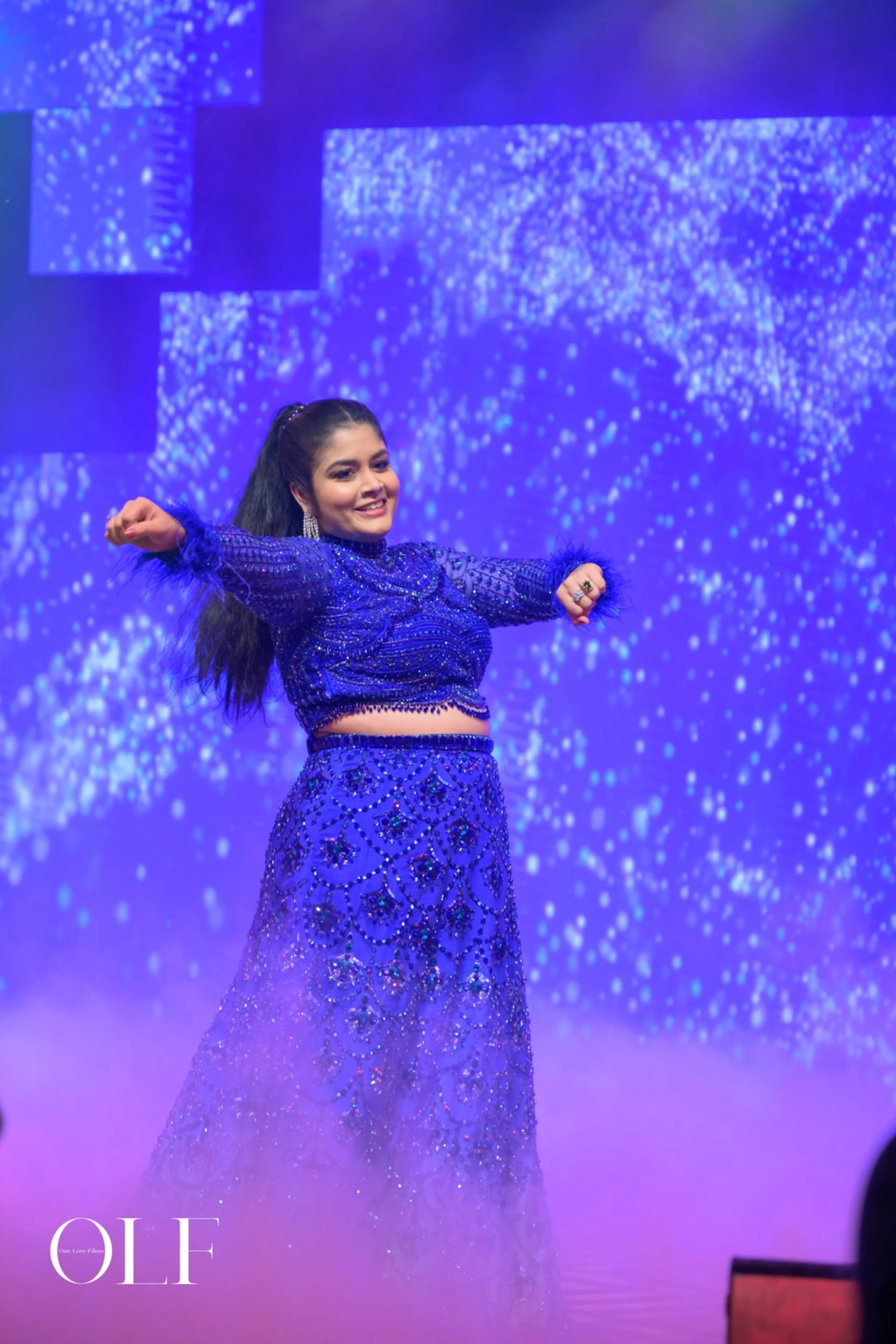 Bride Rasagnya dancing in a peacock themed blue tulle lehenga, handcrafted with rhinestones, crystals, cutdana, sequins and feathers by team Archana Karthick.