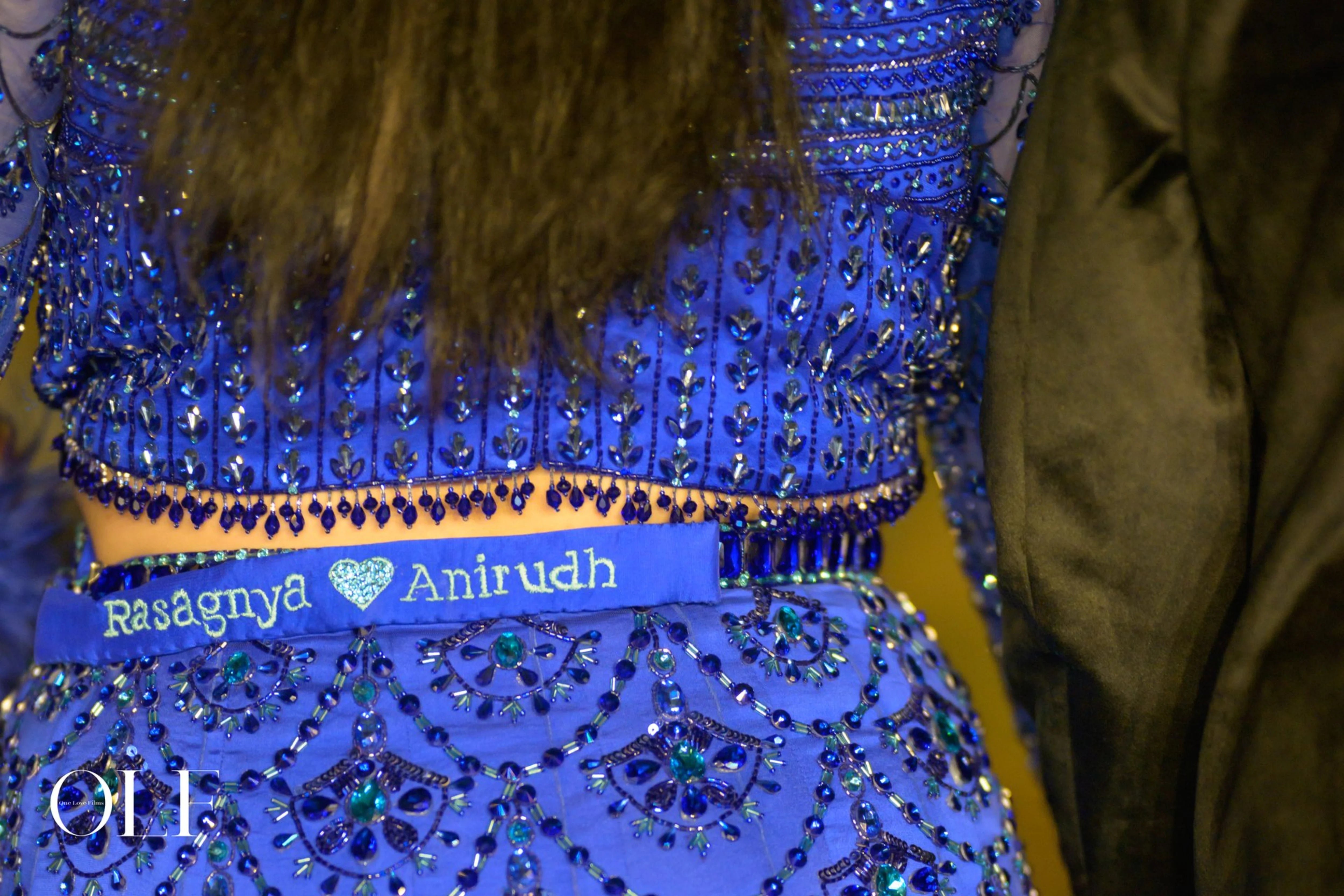 Bride Rasagnya showcasing back design in a peacock themed blue tulle lehenga, handcrafted with rhinestones, crystals, cutdana, sequins and feathers by team Archana Karthick.
