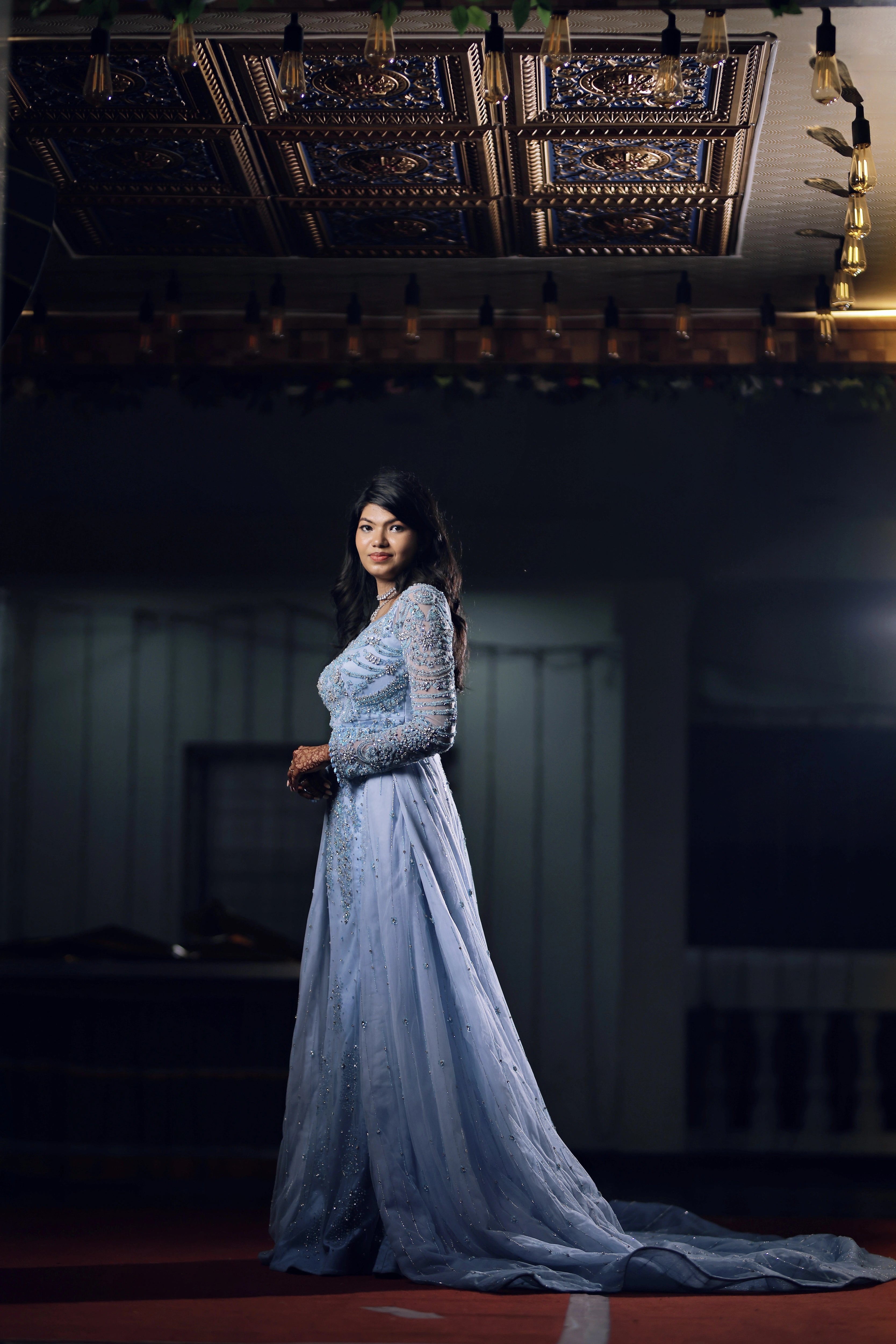 Bride Raxana smiling for photograph in a blue tulle mermaid gown by team Archana Karthick.