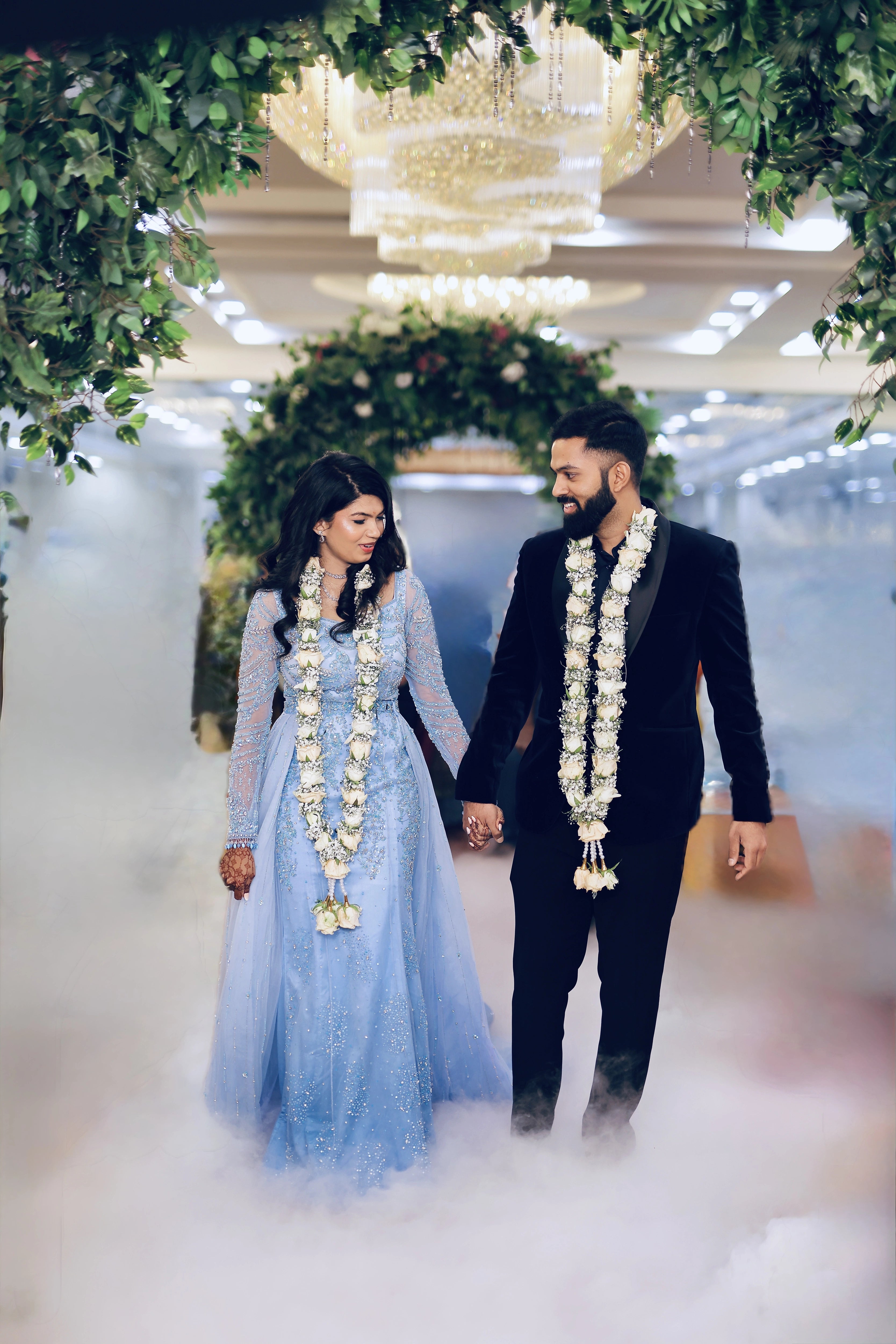 Bride Raxana smiling with groom in a blue tulle mermaid gown by team Archana Karthick.