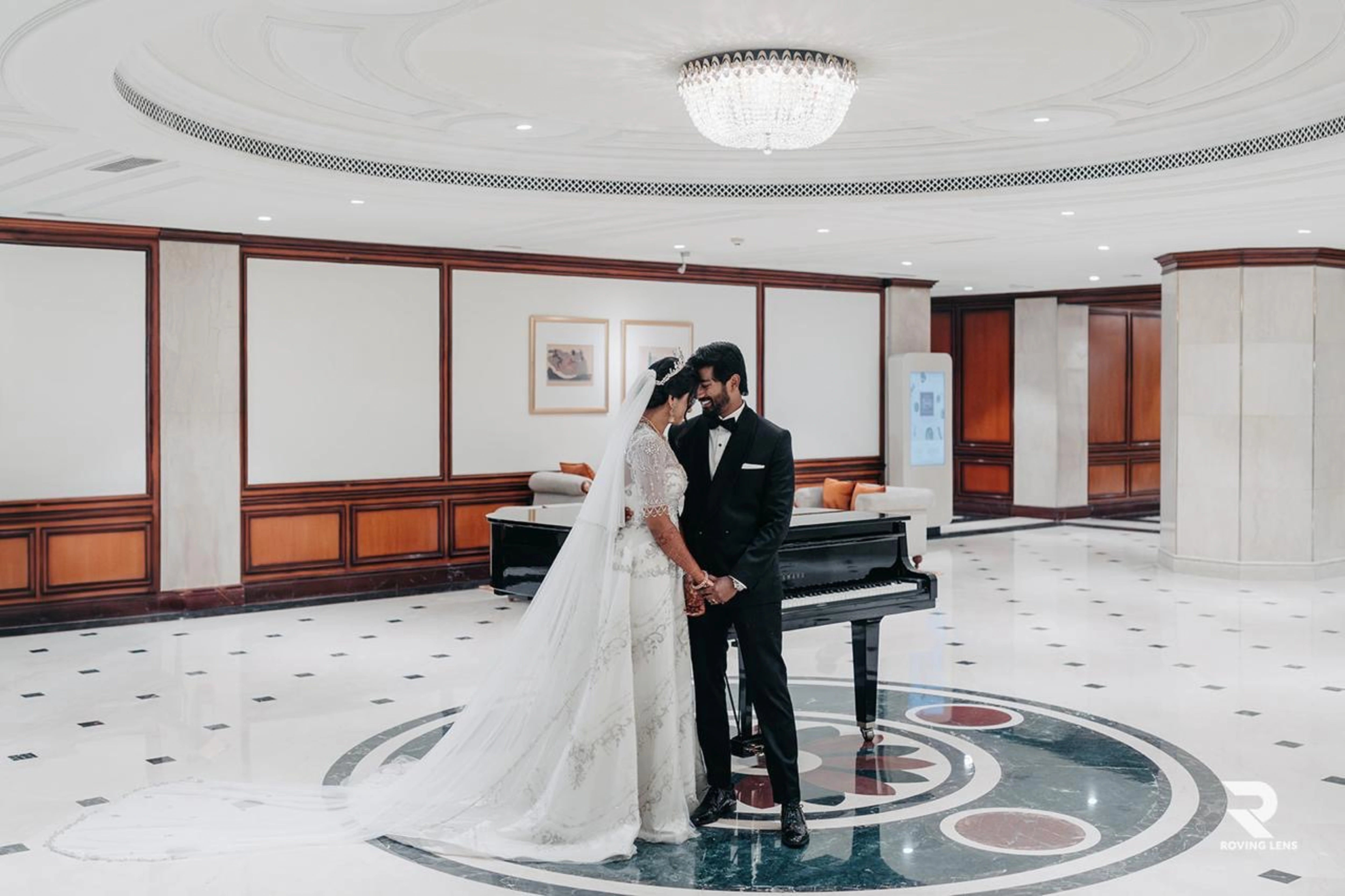 Bride Roushni posing with groom in a white gown for her church wedding by team Archana Karthick.